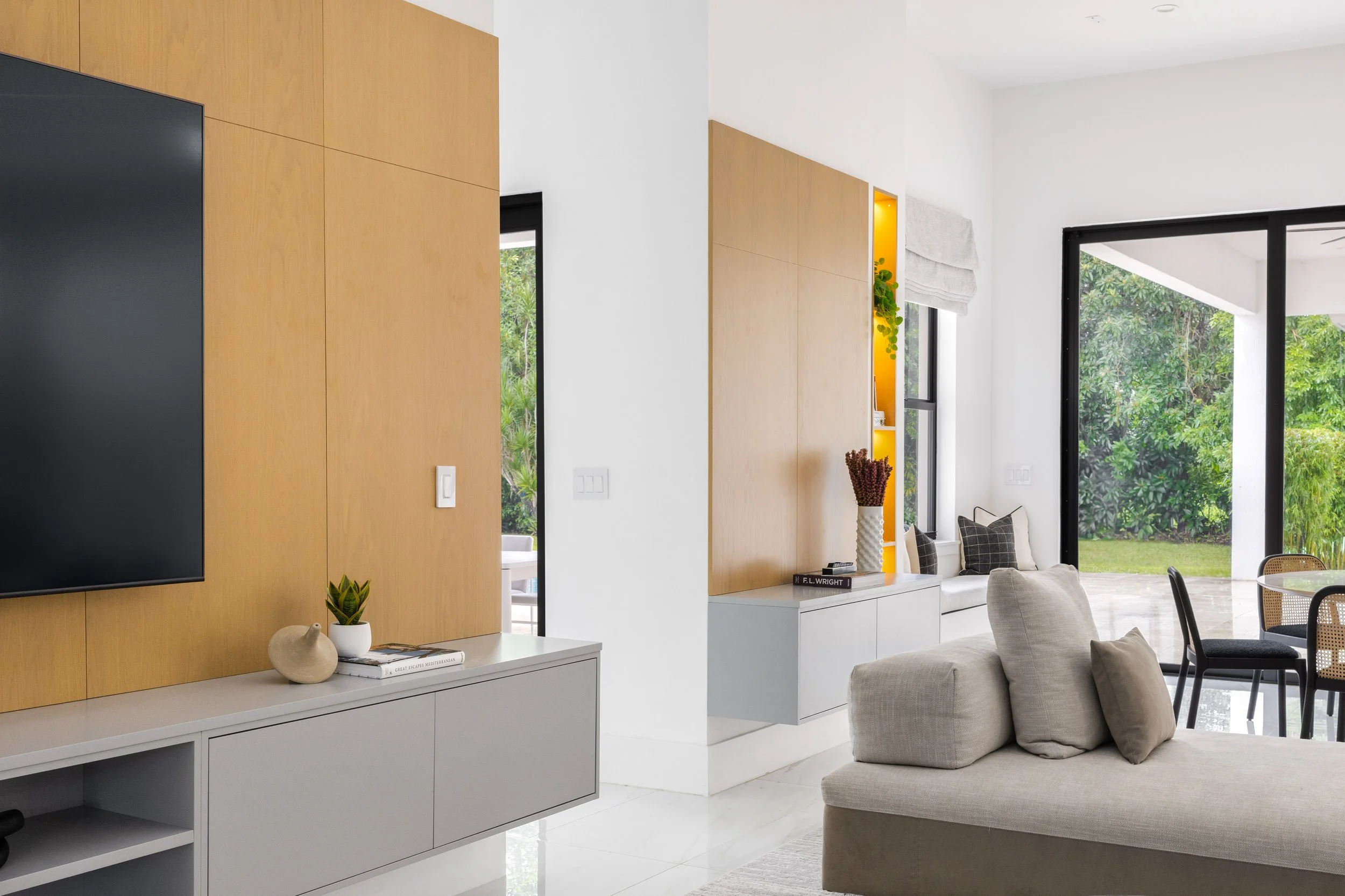 Family room with warm wood paneling and wall mounted tv - Modern Family Estate - Pinecrest - CURATED. Studio