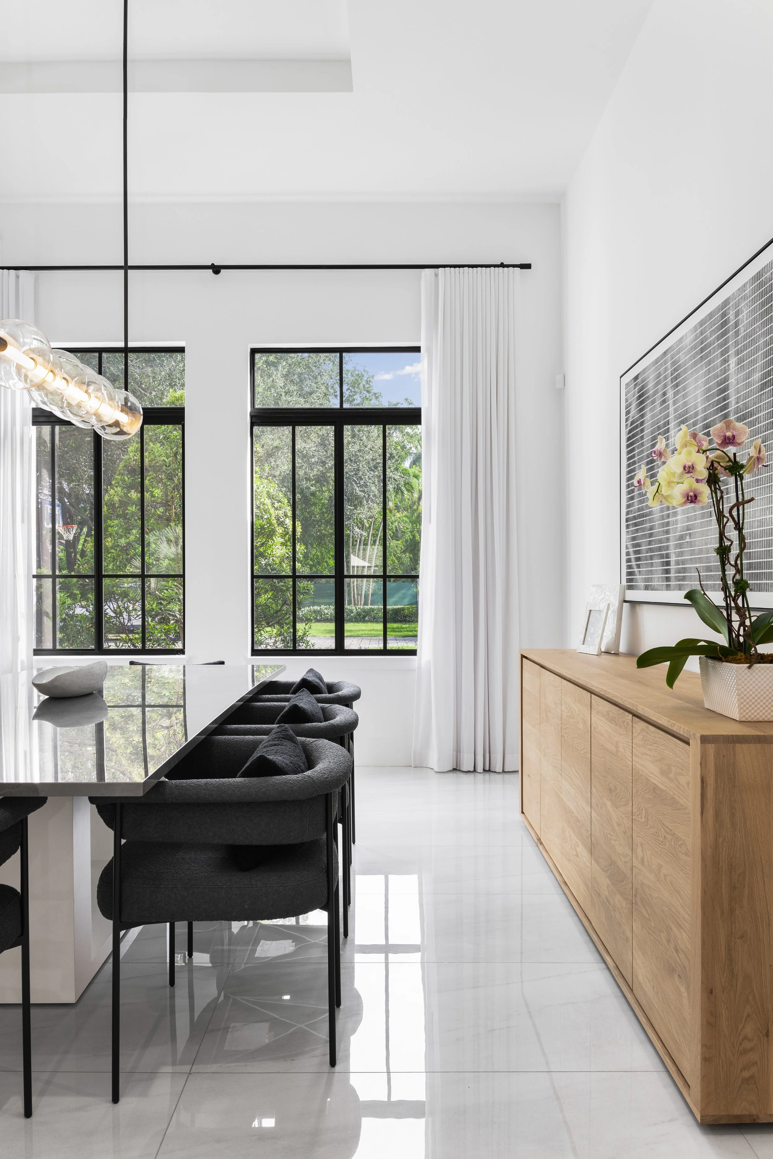 Detail shot of contemporary dining space with dark accent chairs - Modern Family Estate - Pinecrest - CURATED. Studio