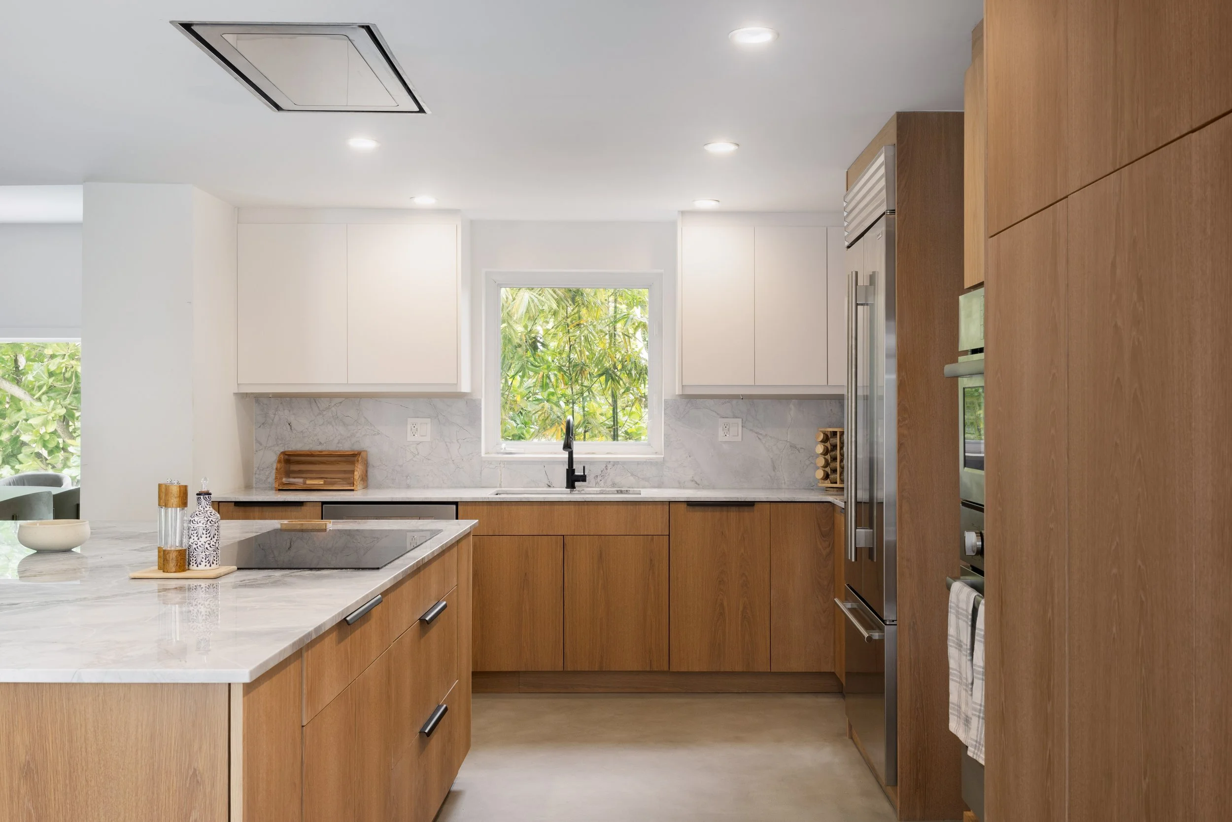 Modern kitchen with white countertops and warm finishes - Modernized Brutalist Architecture - Coconut Grove - CURATED. Studio