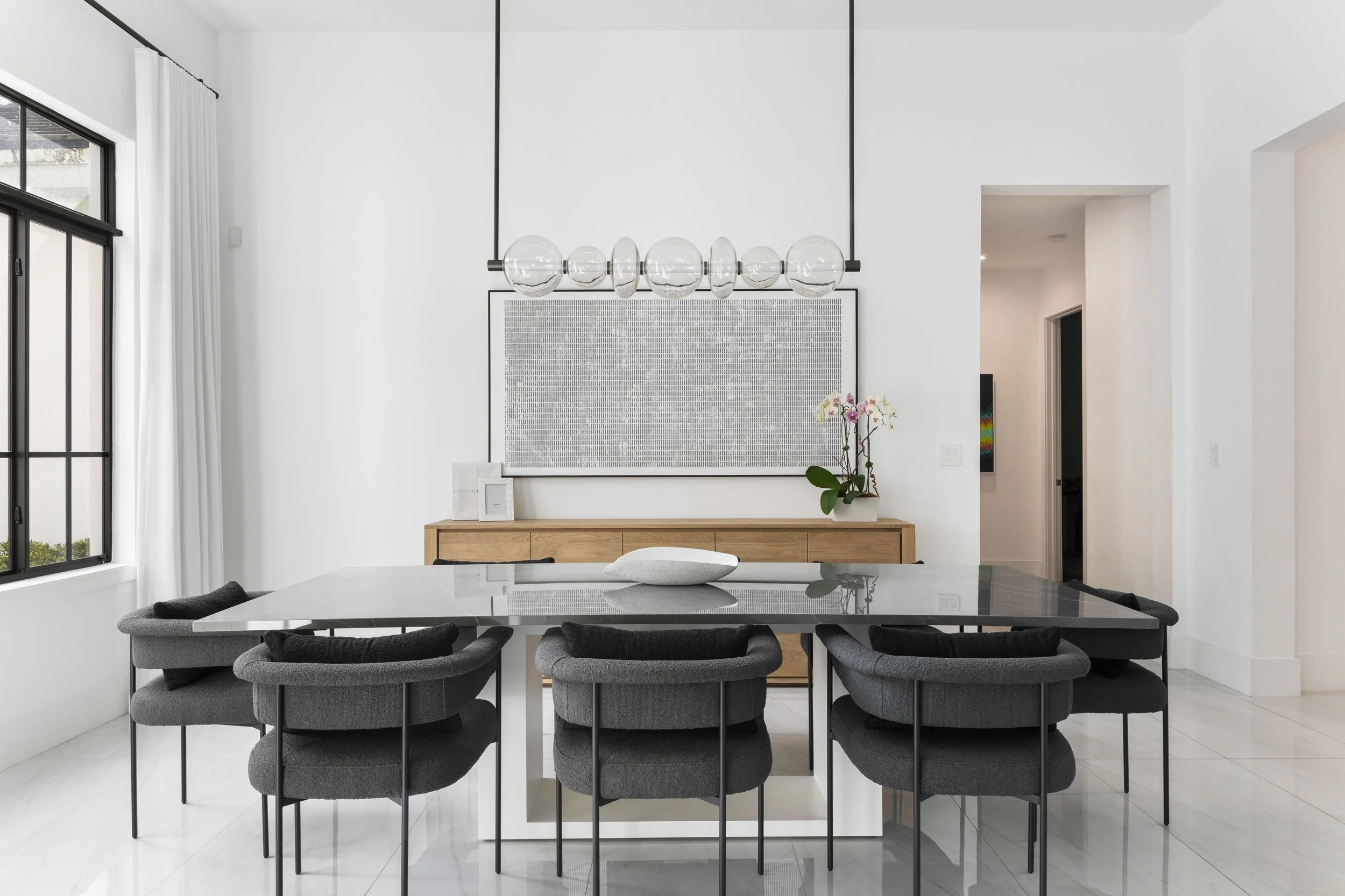 Contemporary dining space with dark accent chairs - Modern Family Estate - Pinecrest - CURATED. Studio