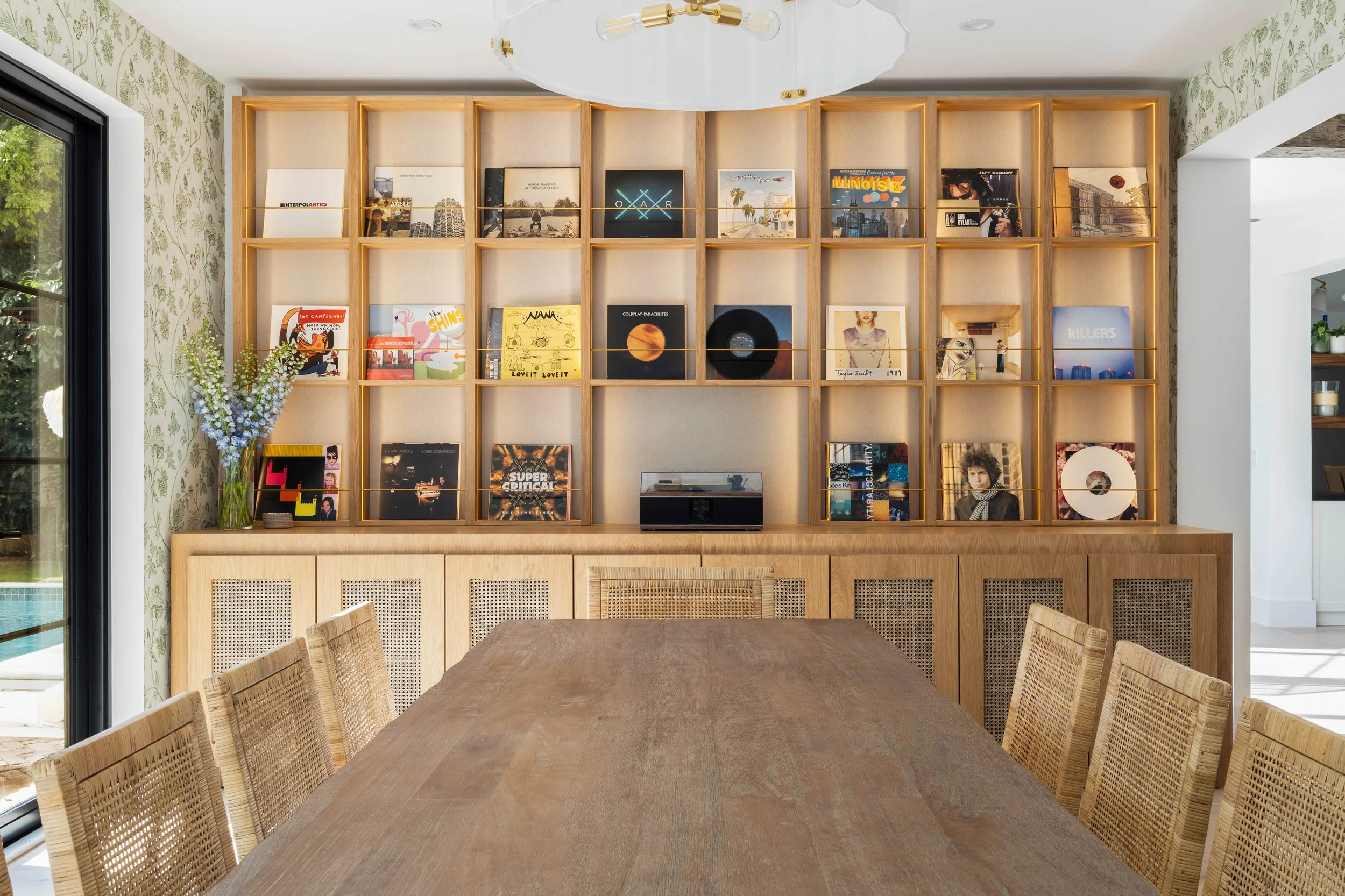 Dining space with custom record wall and wicker chairs - Coastal Boho Estate - Coconut Grove - CURATED. Studio