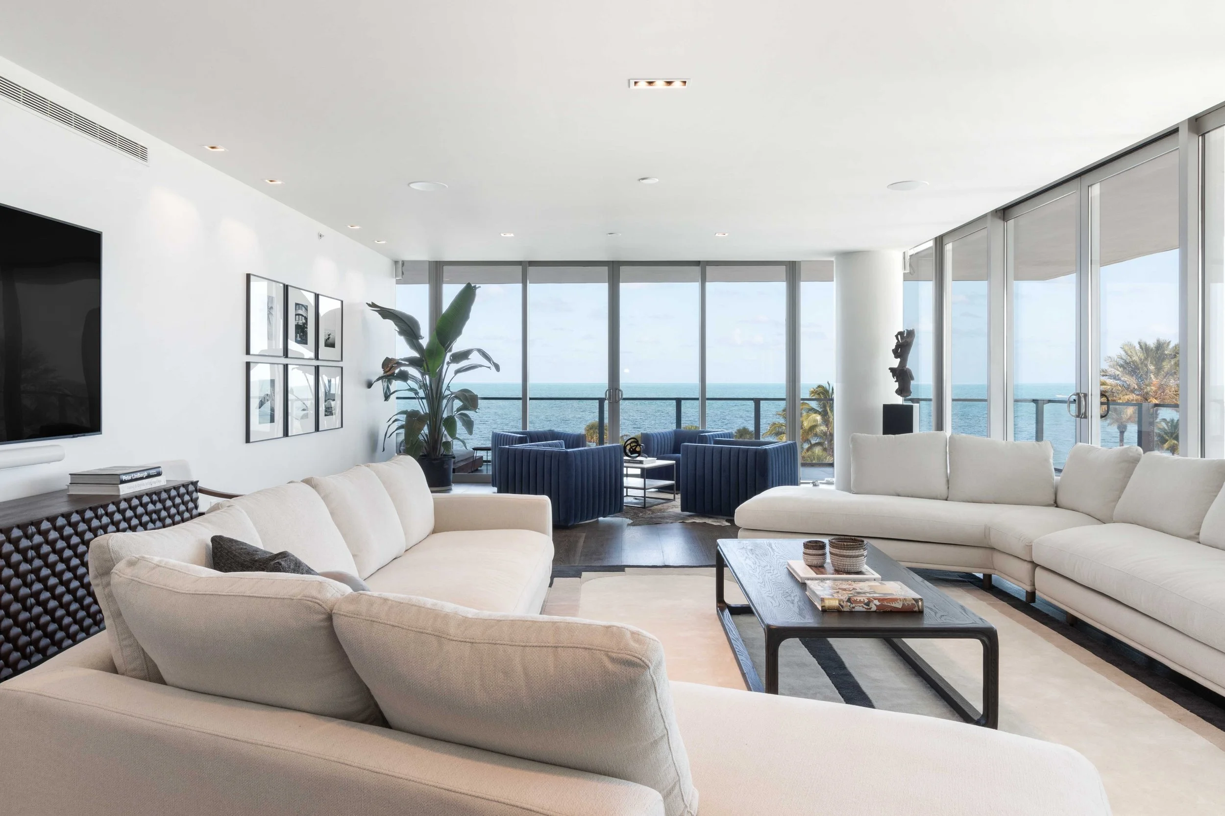Living room with cream sofas and floor-to-ceiling ocean views in Key Biscayne, Interior Design by CURATED.