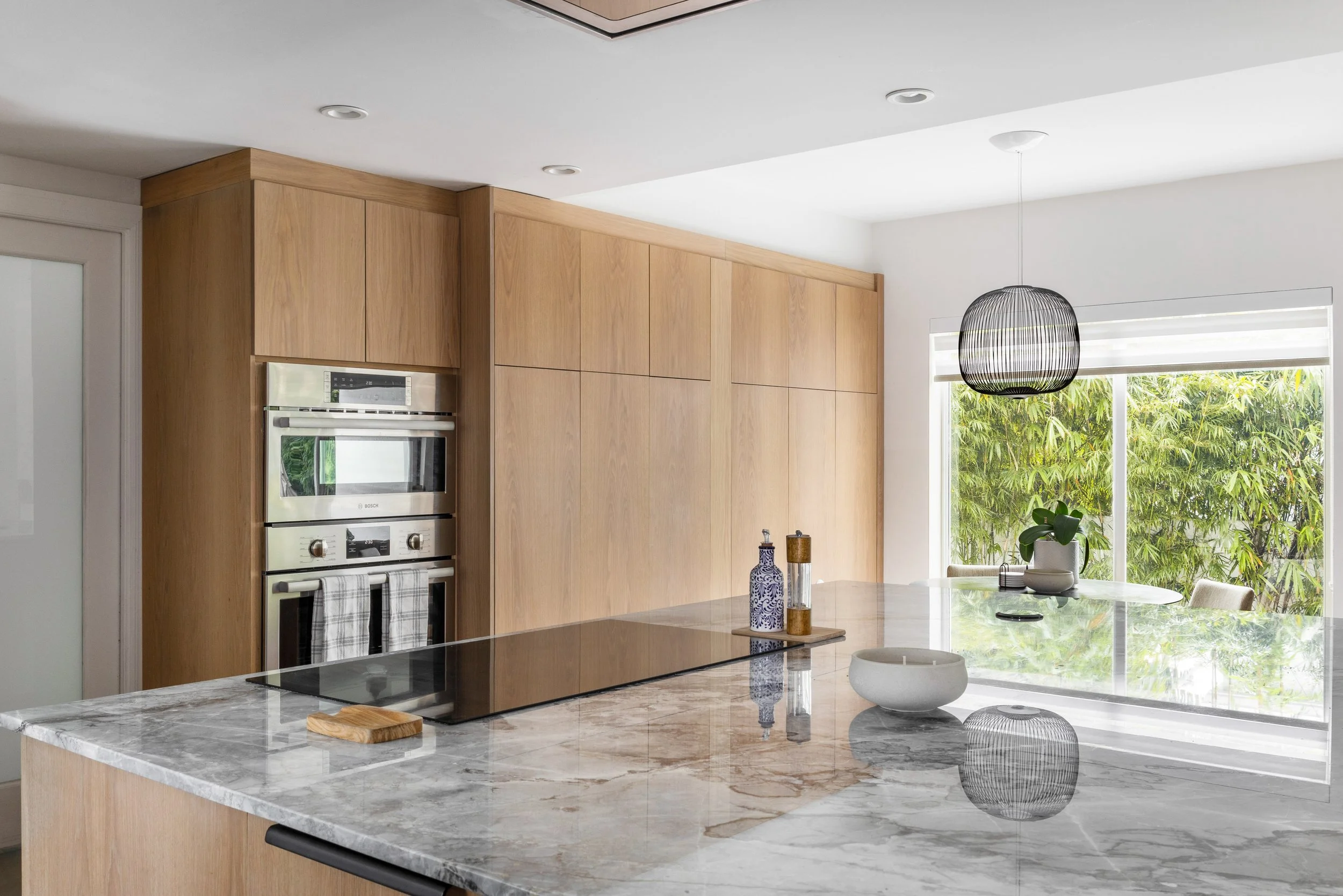 Modern kitchen with marble oversized island - Modernized Brutalist Architecture - Coconut Grove - CURATED. Studio