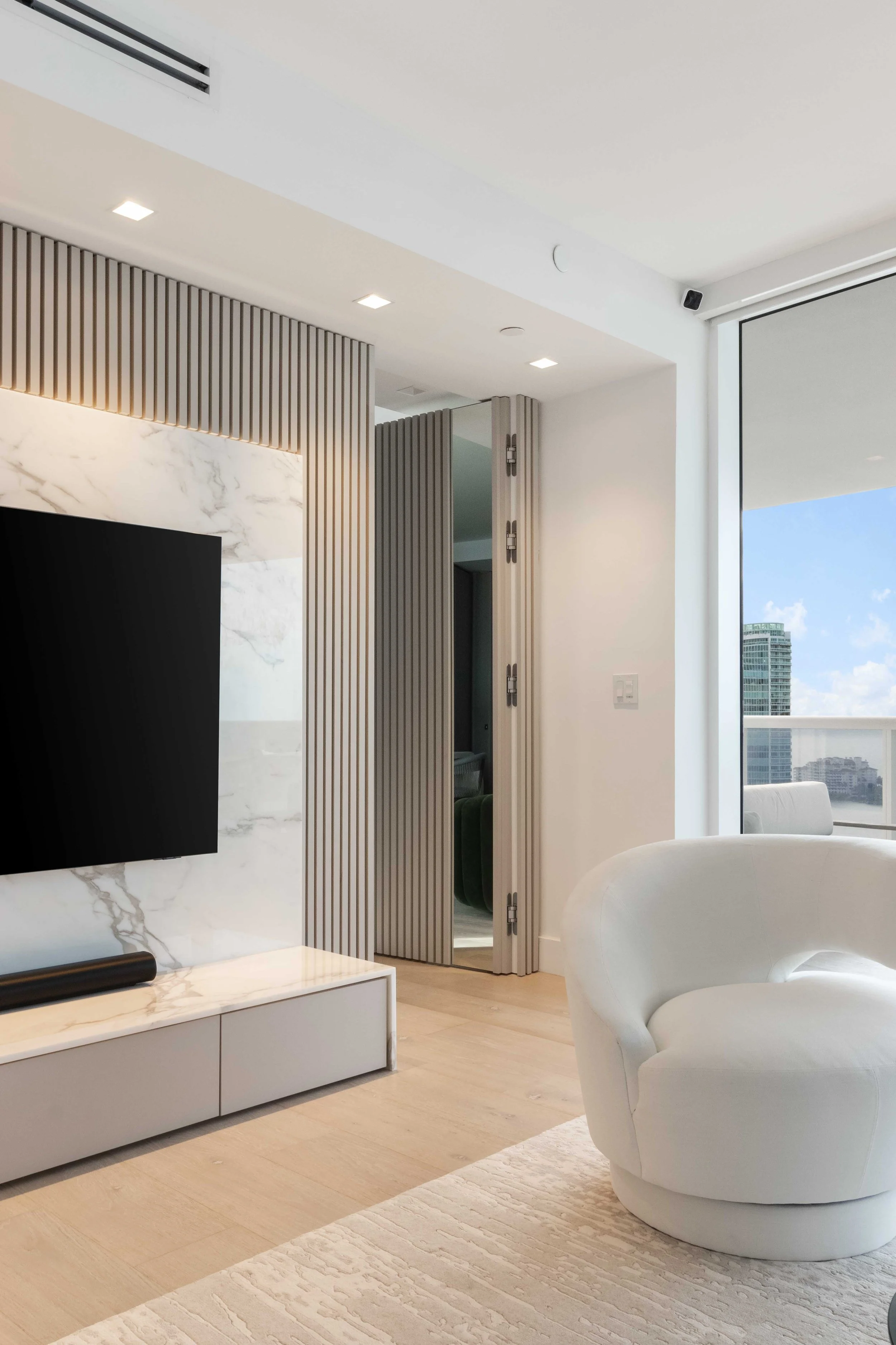 Modern living room with hidden doorway - Murano Grande - South of Fifth Design - CURATED. Studio