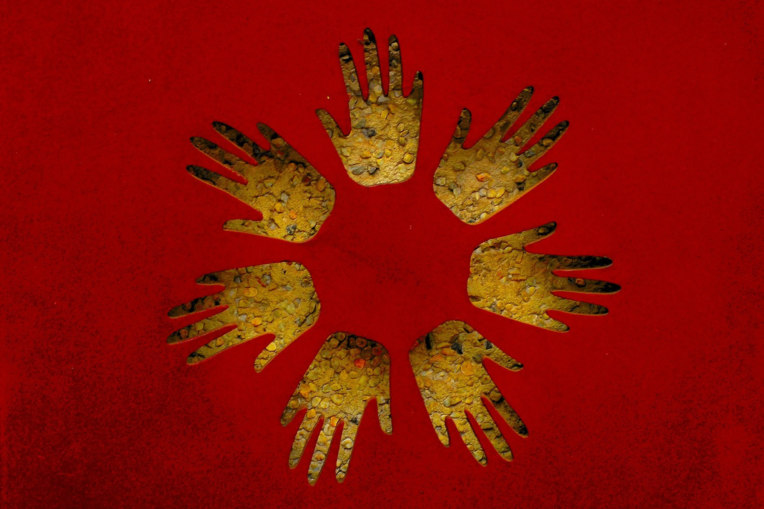 Sechs goldene Handsymbole auf rotem Hintergrund, die einen Kreis bilden.