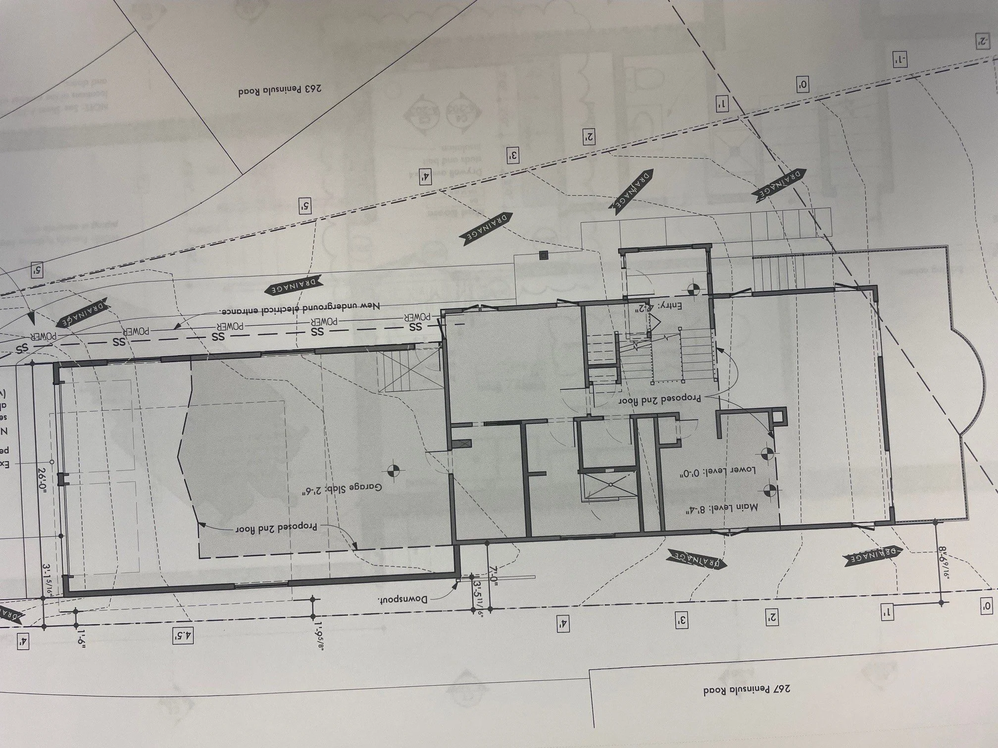 Architectural blueprint of a house with labeled rooms, stairs, doors, windows, and property boundaries.