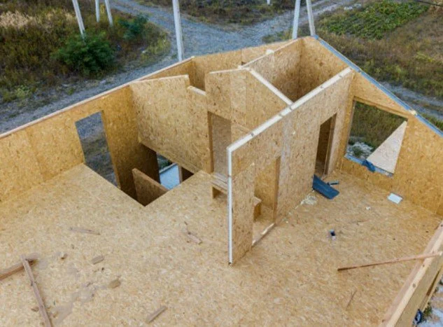 Under-construction wooden house frame with interior walls and openings for windows and doors