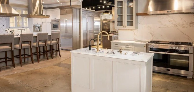 Mountain landscape with snow-capped peaks and a modern building on a grassy hill in the foreground.