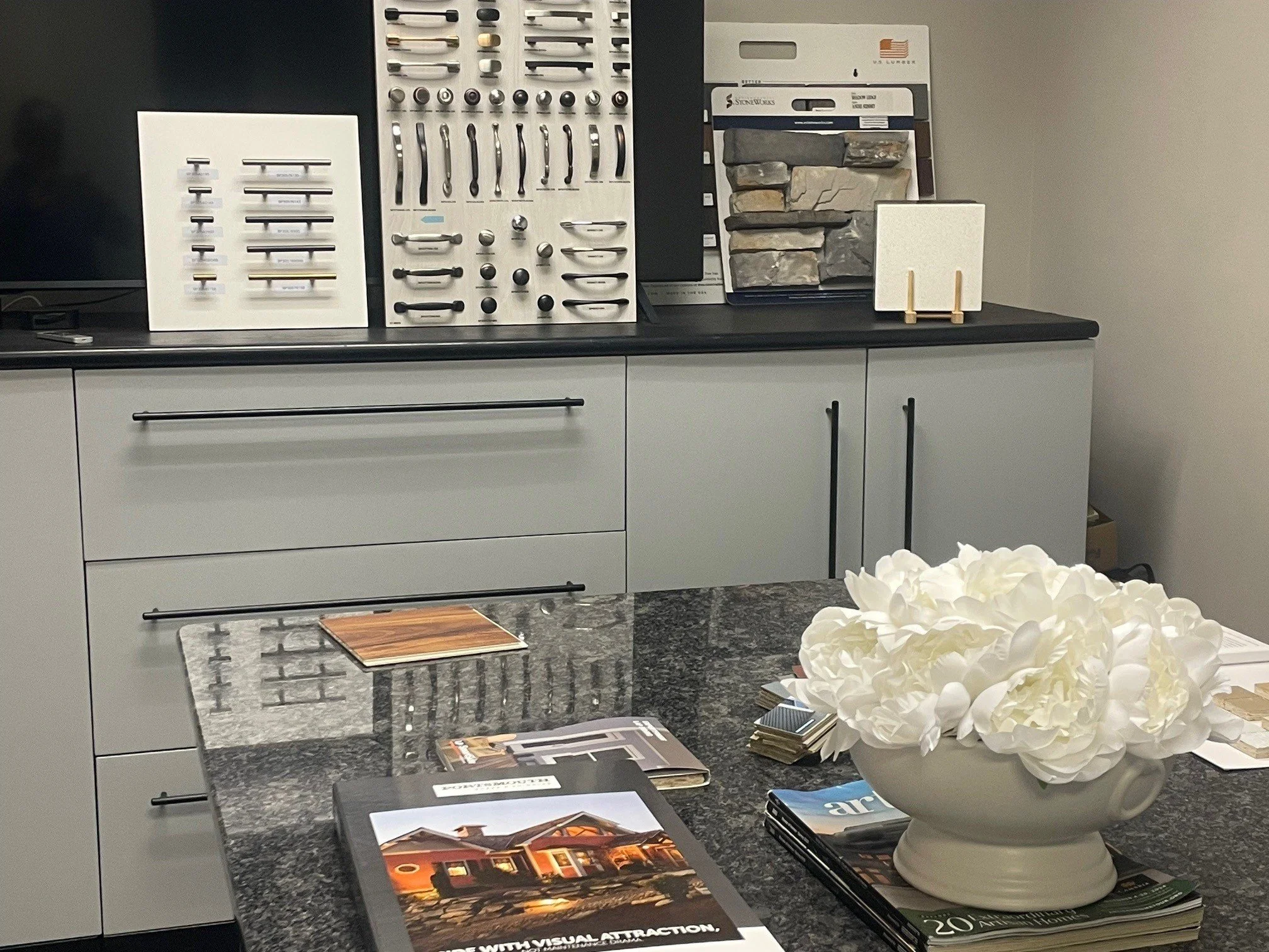 A landscape of a large turquoise lake surrounded by green and brown rolling hills and mountains under a cloudy sky.
