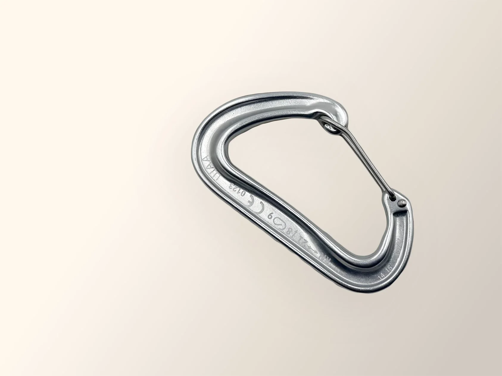 A silver metal carabiner clip on a plain light-colored background.