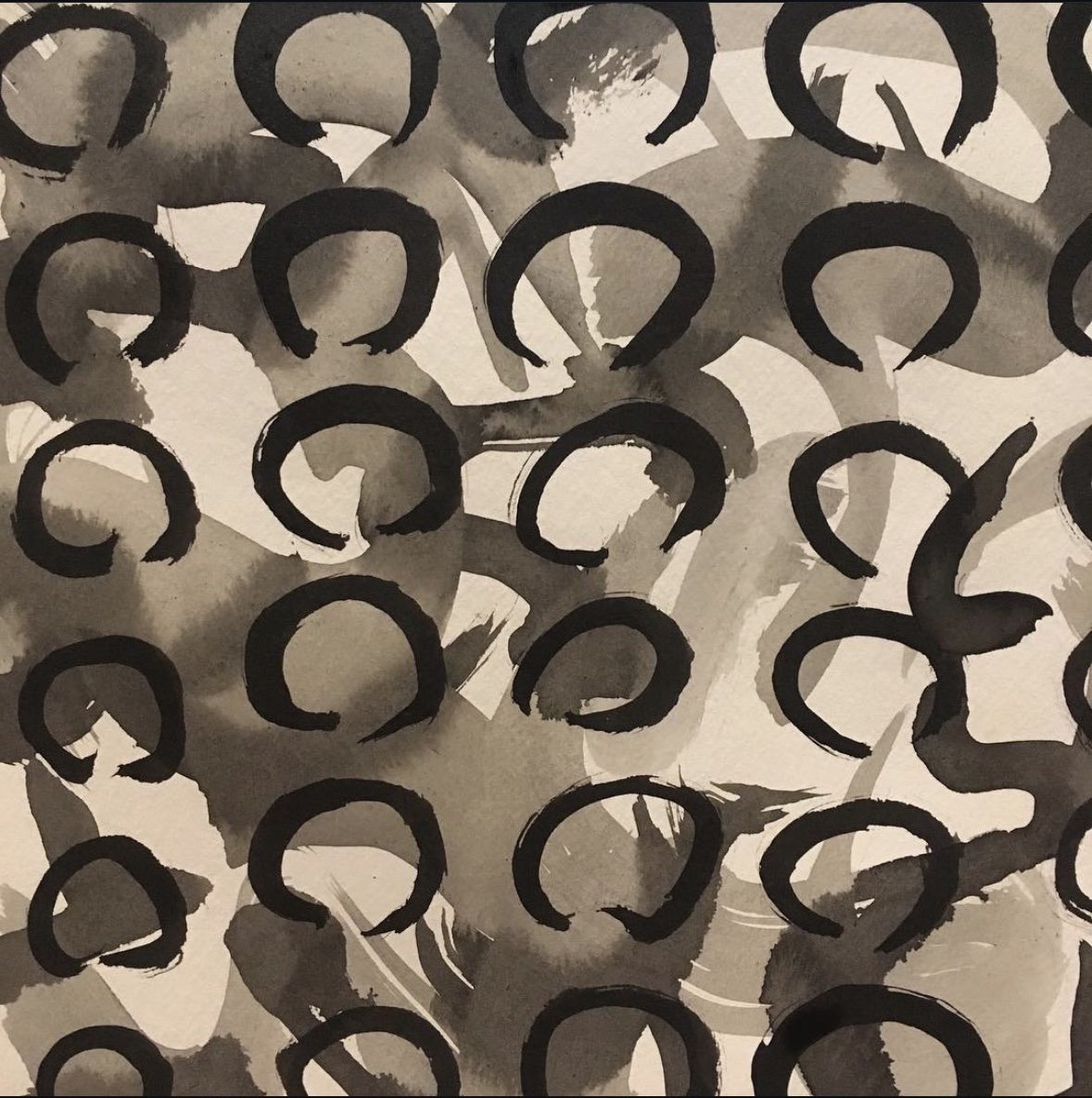 Abstract black and gray watercolor background with black circular brush strokes.