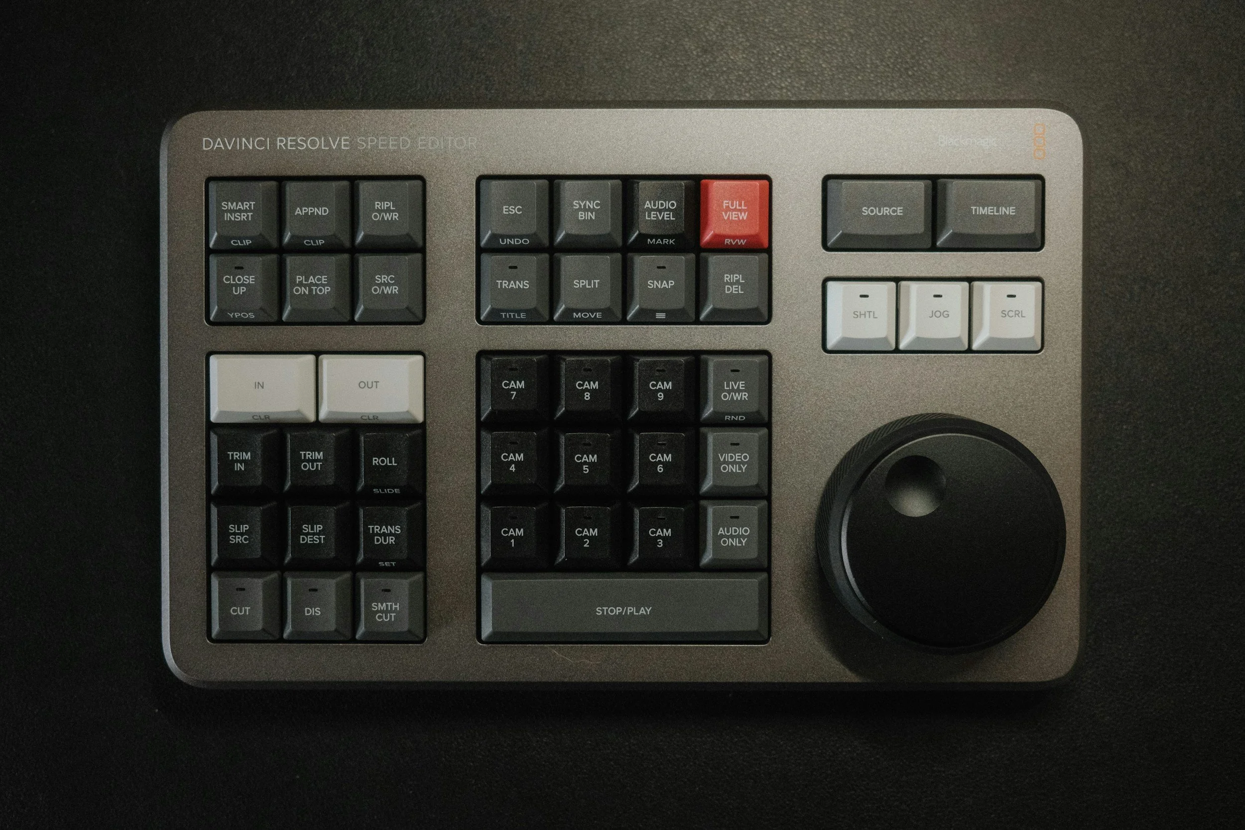 Ein professionelles Videobearbeitungs-Controller mit zahlreichen Tasten und einem großen Drehknopf auf einer dunklen Oberfläche.