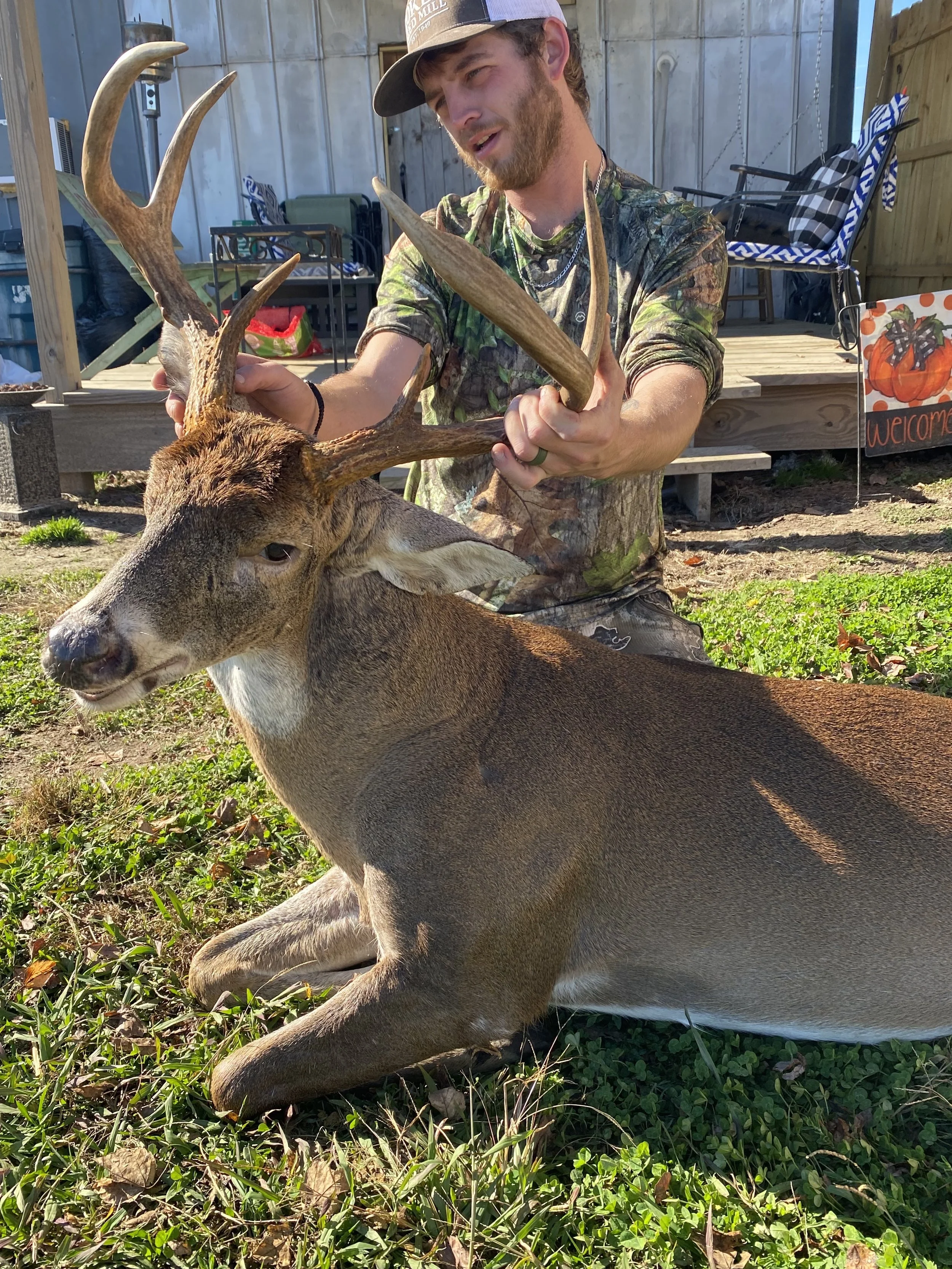 A man with dark hair holding a deer.