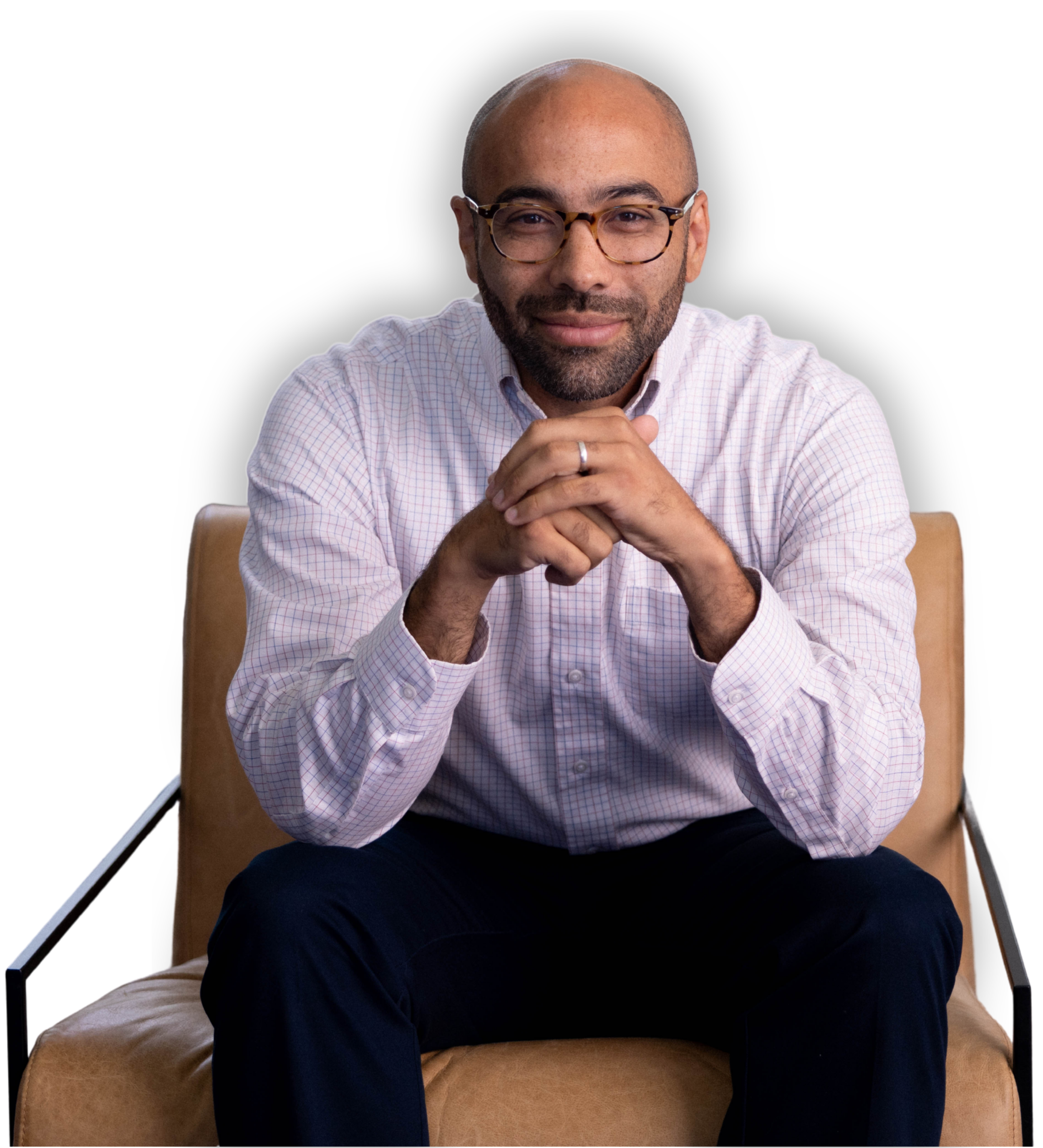 A man sitting on a tan chair against a black background, wearing glasses  | Dr Matthew Breuninger | Therapist, Catholic Speaker, Course Creator, and Author | Steubenville, OH