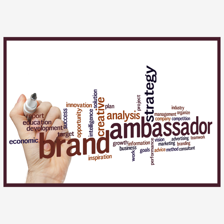Word cloud with terms related to branding, marketing, and business strategy, including 'brand,' 'ambassador,' 'strategy,' 'creativity,' 'analysis,' and 'education,' with a hand holding a marker writing or highlighting the words.