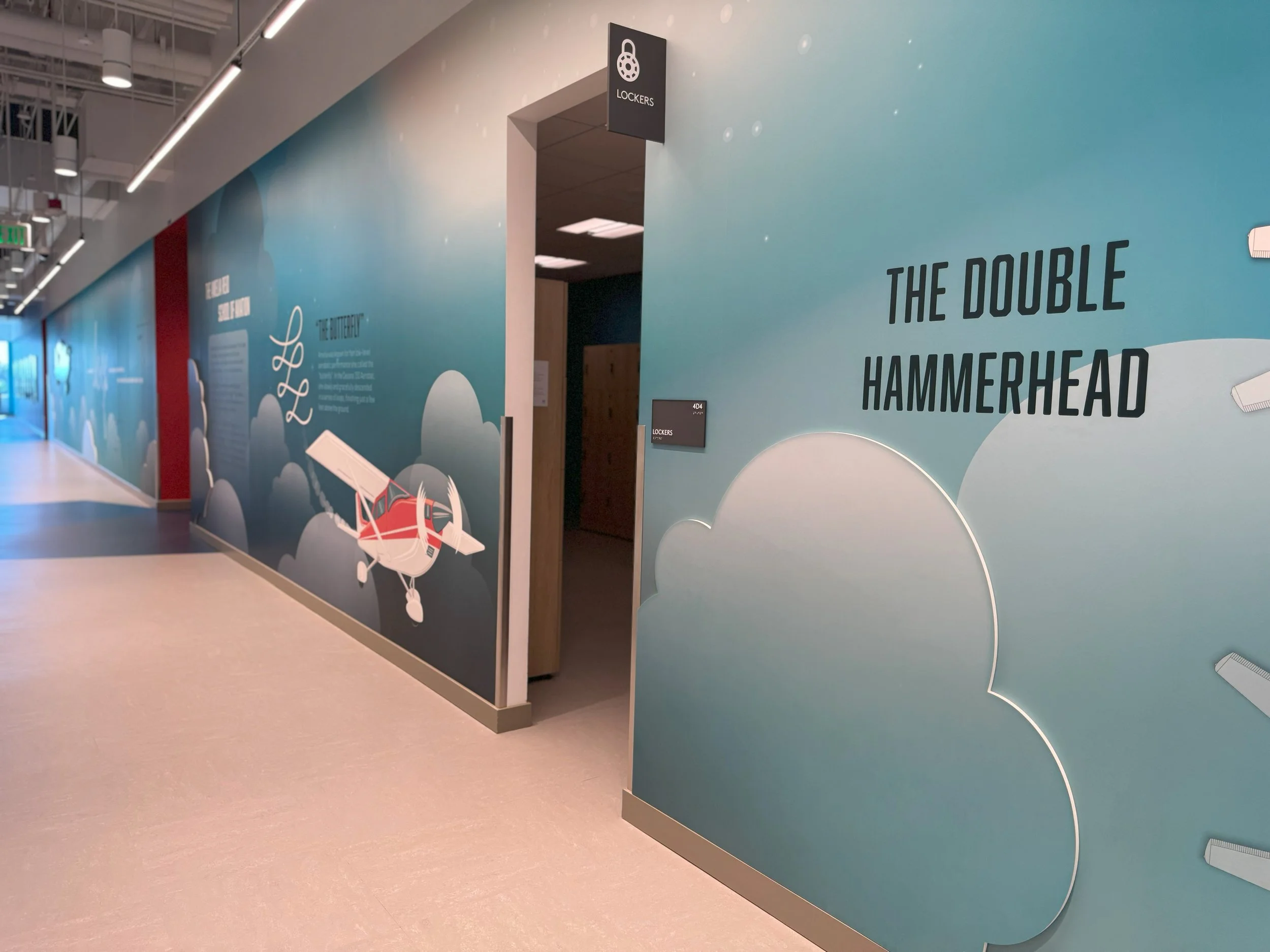 Thematic corridor graphics and room identification creating a cohesive environmental branding system.