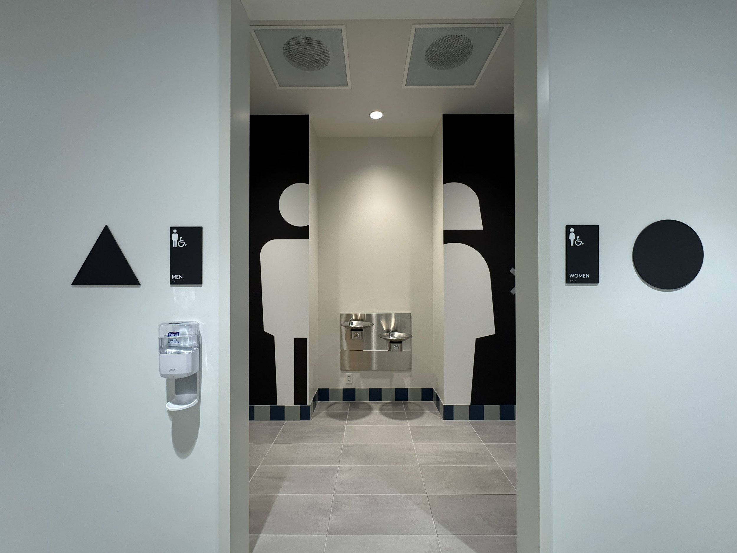 ADA-compliant restroom signage and large-scale environmental graphics installed for accessible wayfinding in commercial interior space.