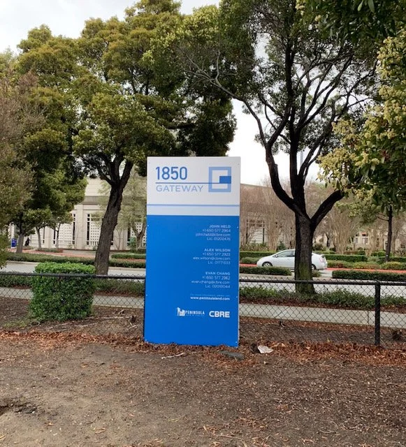 Freestanding exterior monument signage displaying building address and wayfinding information for corporate campus entrance