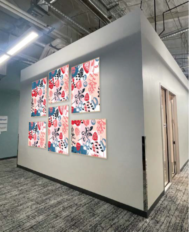 Framed environmental graphic panels installed on a hallway feature wall in an amphitheatre workspace, adding color and visual interest to the corridor.