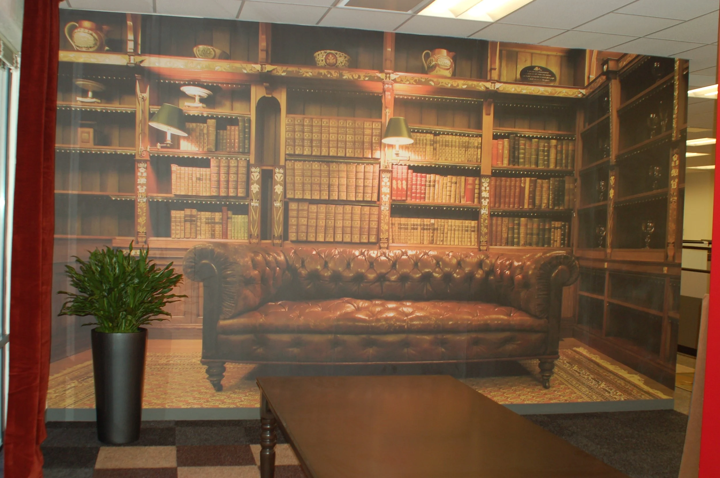 Library-themed mural wallcovering creating a warm, immersive feature wall in a commercial interior.