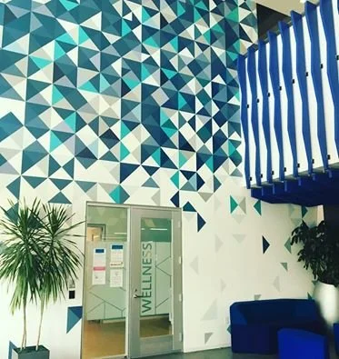 Dimensional geometric wallcovering design creating a modern feature wall in a corporate lobby.
