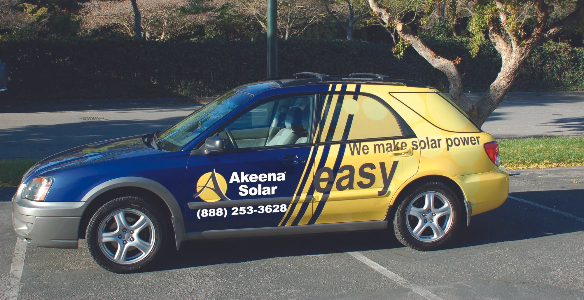 Partial vehicle wrap on company car with logo, graphics, and brand messaging