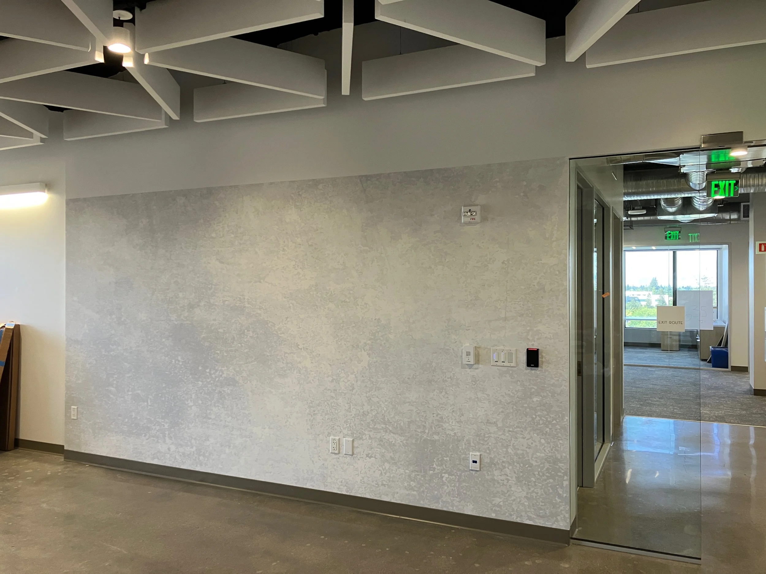 Pre-installation feature wall at Jazz Pharmaceuticals Palo Alto office showing textured wall finish prior to logo or branded graphic installation.