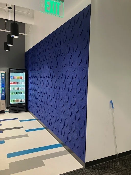 Textured blue acoustic feature wall installed to reduce noise and add visual impact in commercial office environment