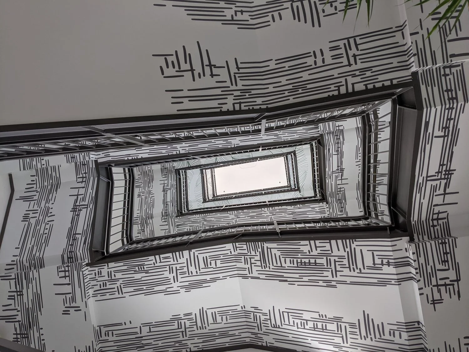 Commercial ceiling vinyl in a stairwell featuring custom printed graphic vinyl for architectural impact