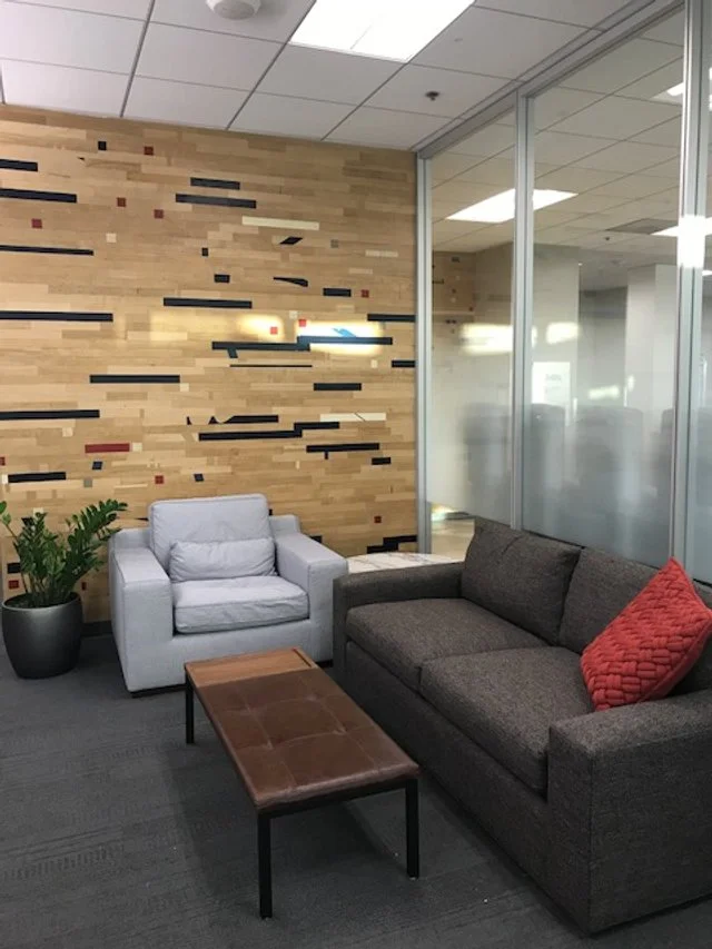 Modern office lounge with decorative wood slat wall panels and commercial interior seating area