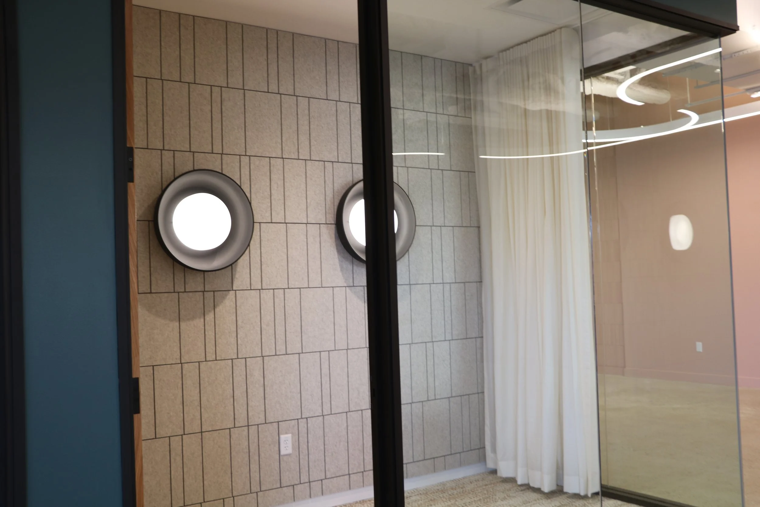 Acoufelt Fracture Barcode acoustic wall panels in Quartz installed in glass-enclosed office space for sound control and modern interior design.