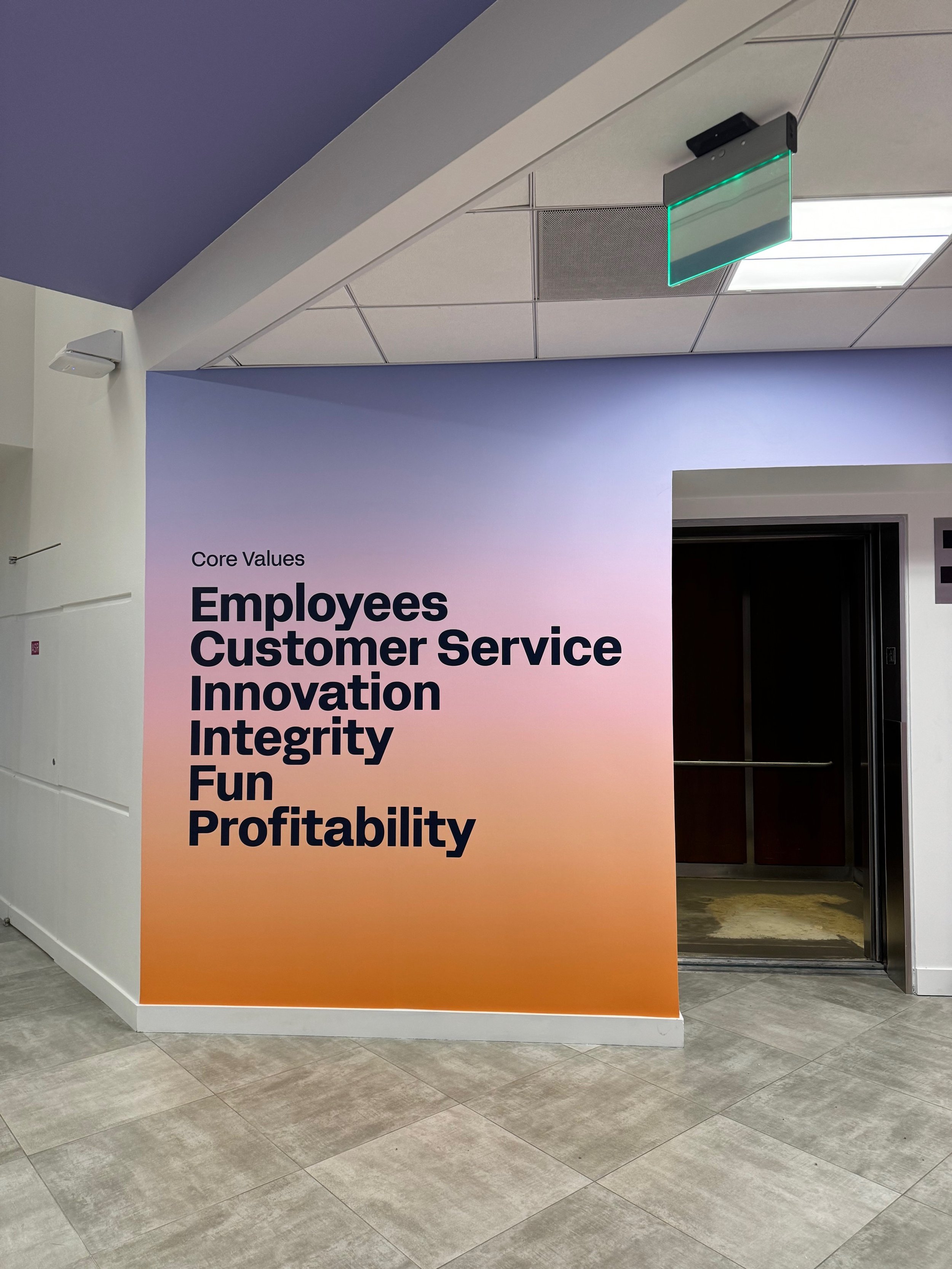 Branded mission statement wall graphic installed in a corporate hallway to communicate company values.