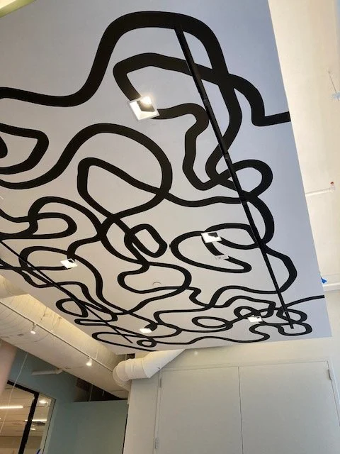 Alternate angle of installed abstract ceiling environmental graphic at eBay New York office showing suspended dimensional feature within workplace corridor