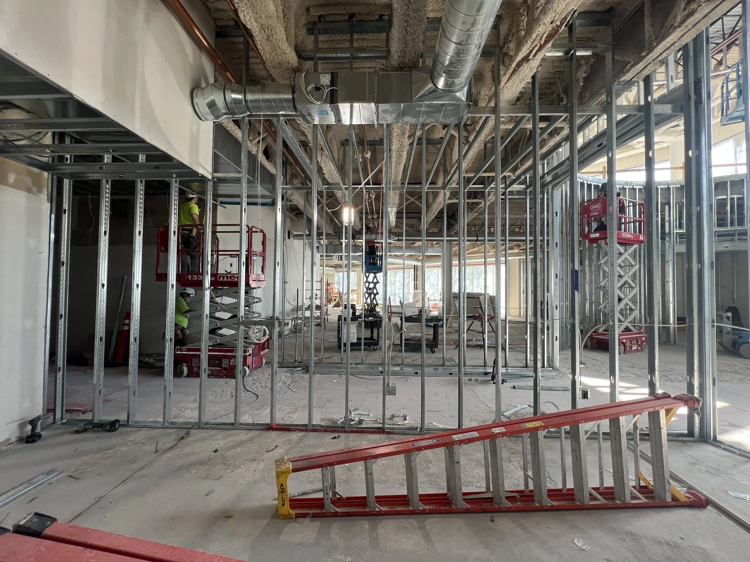 Commercial breakroom kitchen featuring patterned wallcovering designed for high-traffic workplace environments under construction