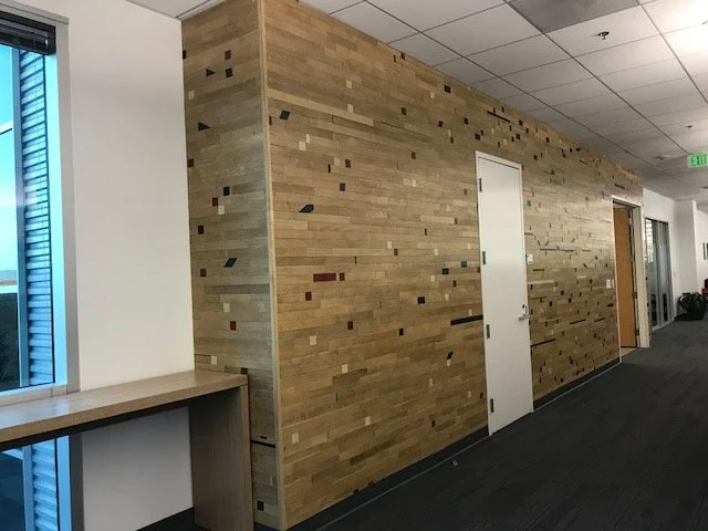 Natural wood plank feature wall installed in corporate corridor for warm architectural finish
