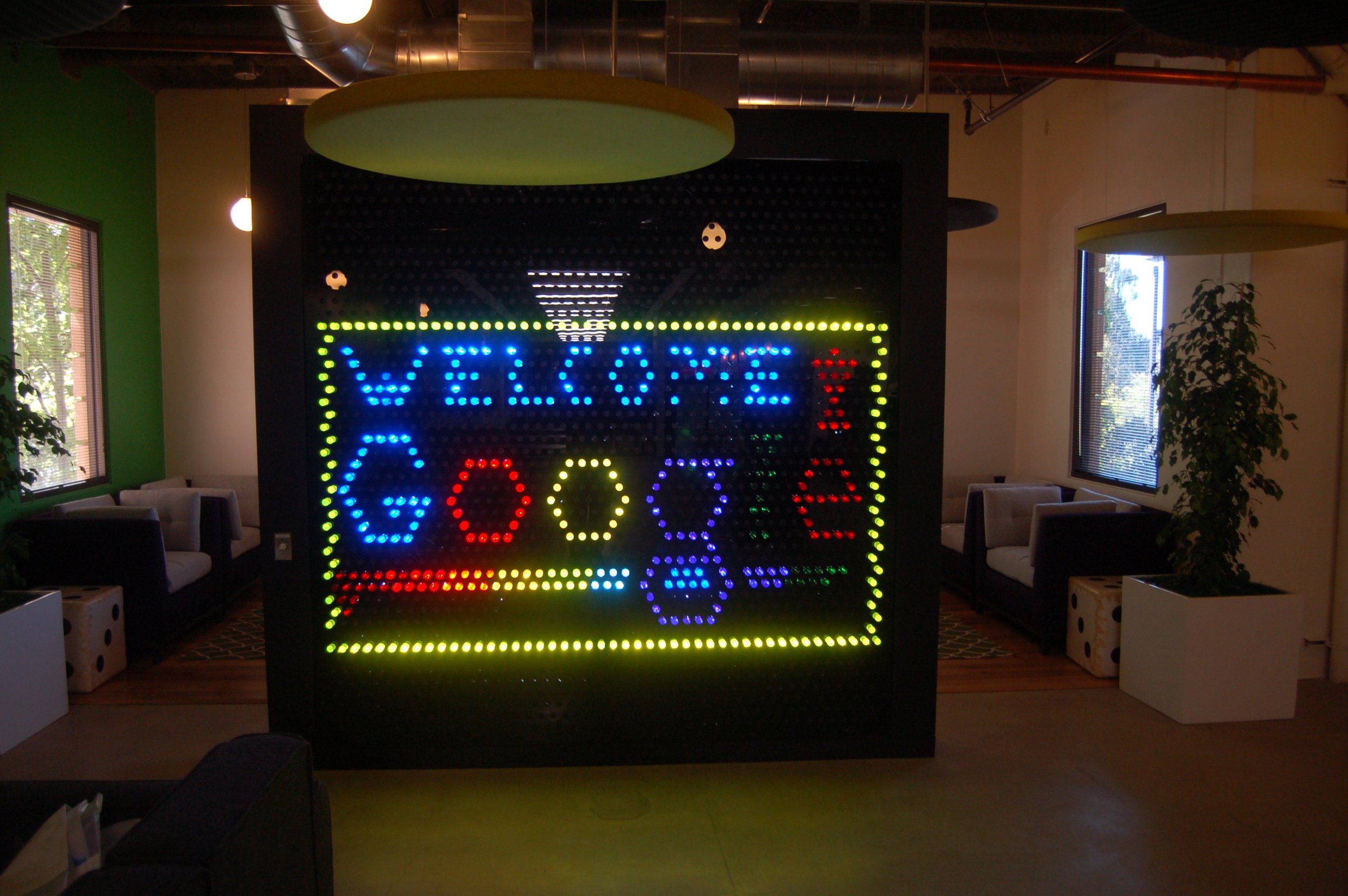 Custom illuminated LED feature signage creating an interactive branded environment and visual focal point in corporate workspace