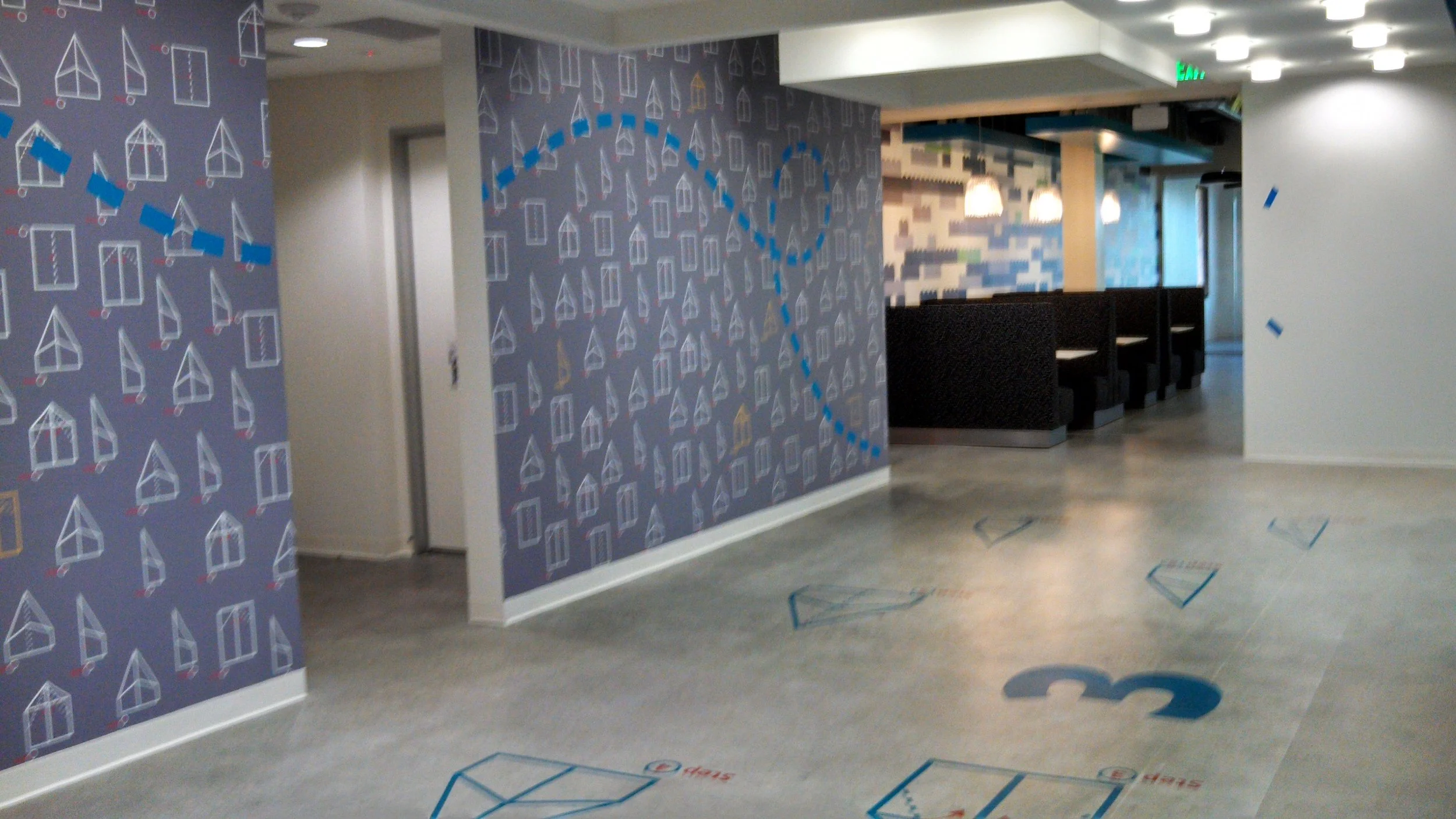 Interactive wayfinding floor graphics with paper plane icons designed to guide movement through workplace