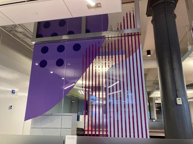 Final installation of custom purple glass film environmental graphics at eBay New York office showing branded workplace glazing from alternate angle
