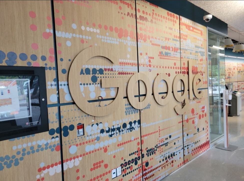 Custom printed wood wall featuring company branding and environmental graphics in corporate office