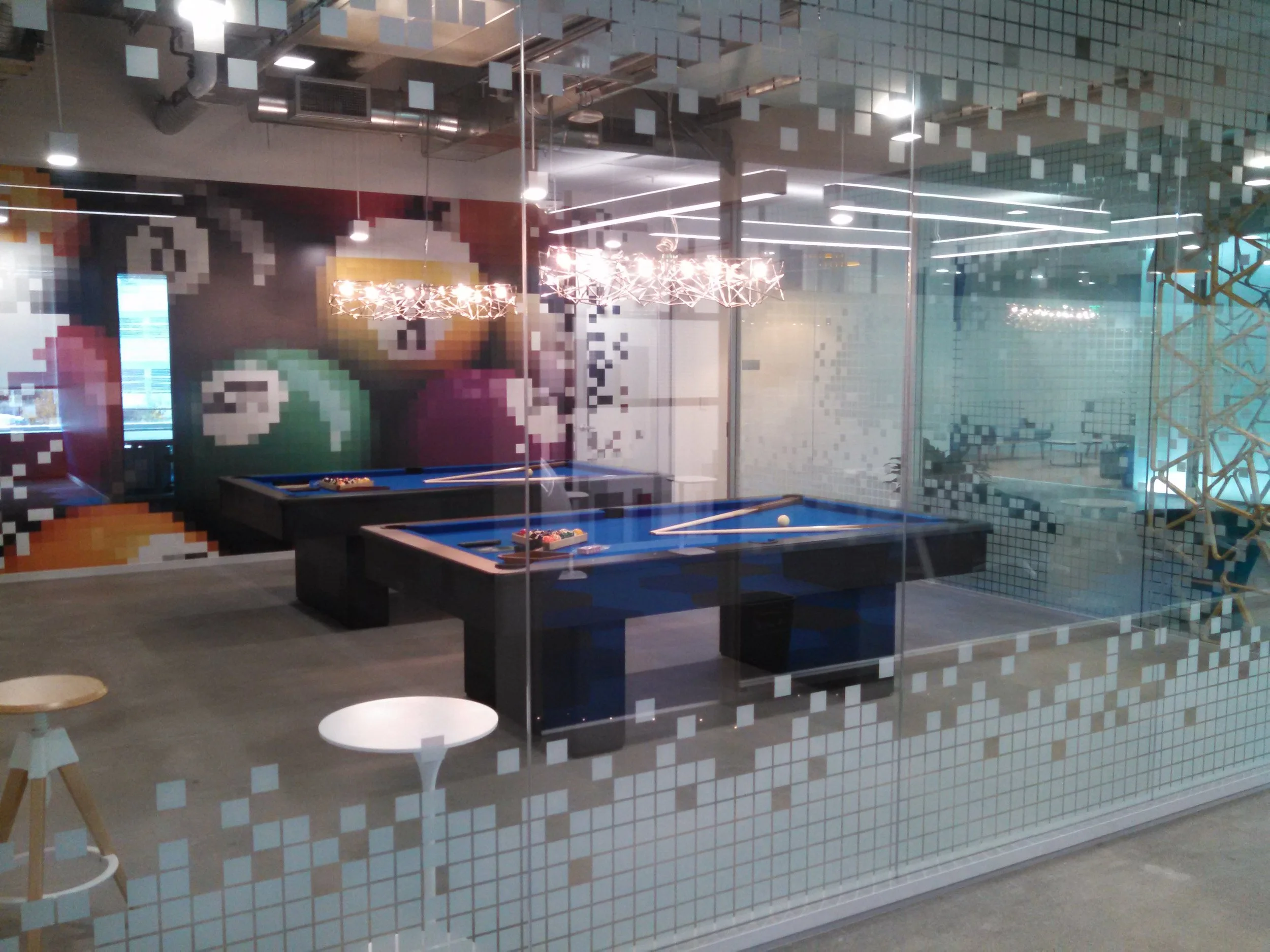 Frosted and patterned window film used for office branding and privacy in a collaborative workspace environment.