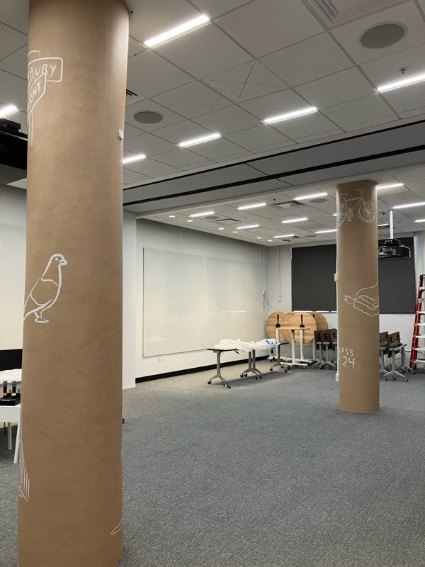 Interior view of Pinterest San Francisco workspace with custom icon-inspired wallcovering applied to architectural columns for cohesive workplace branding by JP Digital.