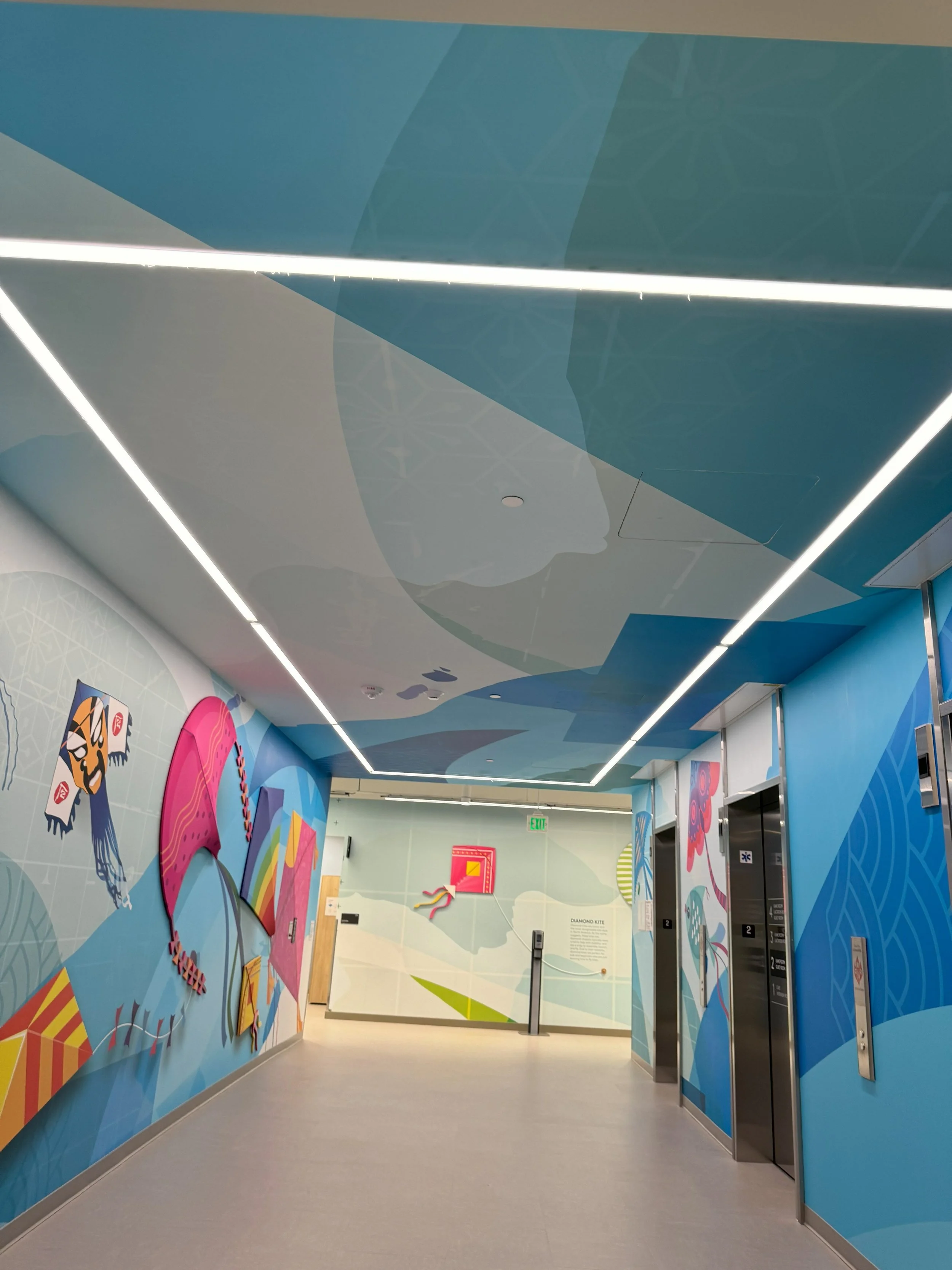 Full-wall environmental mural creating a vibrant visual experience while guiding movement through the office space.