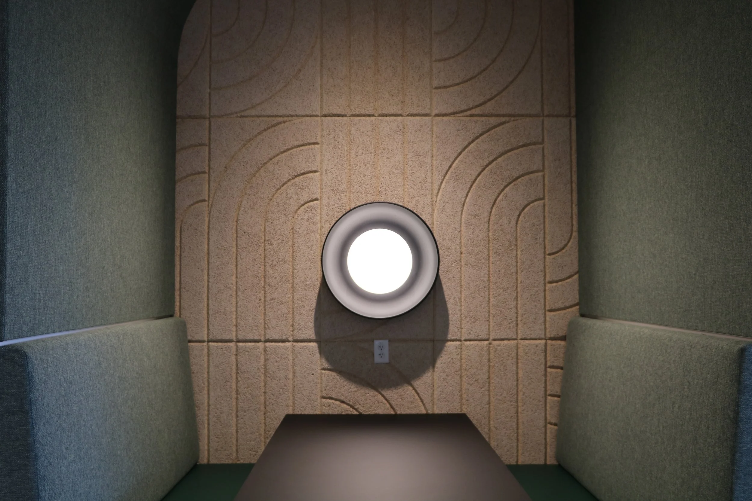 BAUX Wood Wool Curve acoustic panels installed in private office booth with integrated lighting for enhanced sound control and workplace comfort.