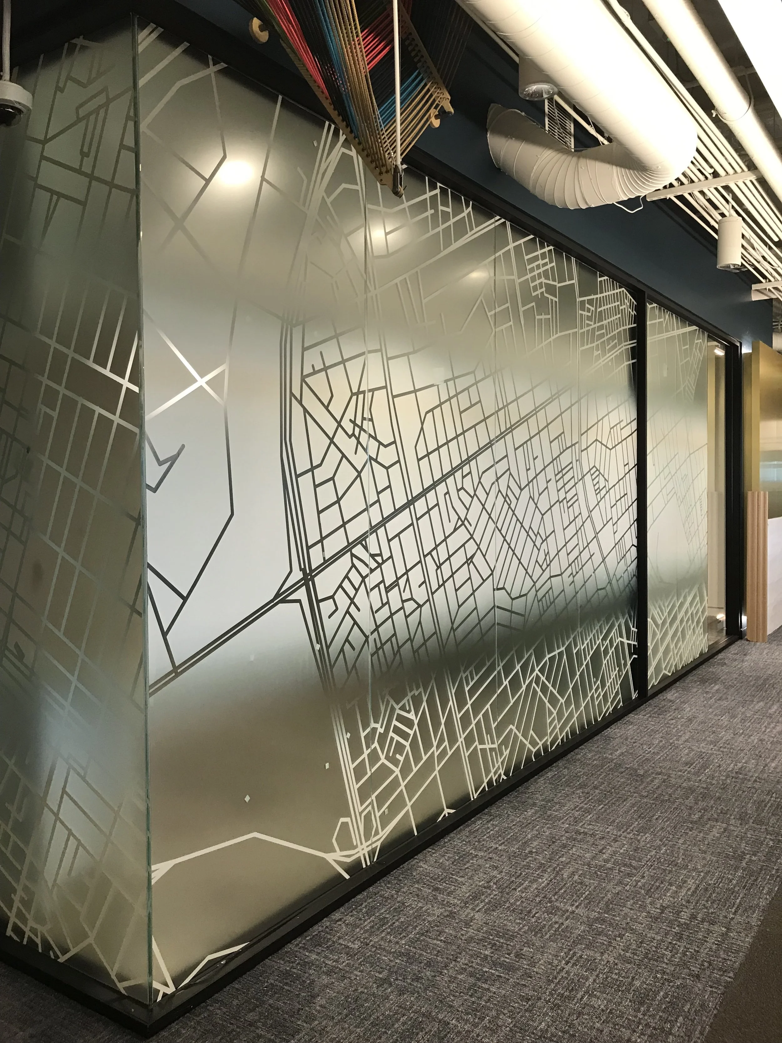 Decorative patterned window film applied to large glass office wall for branding and privacy