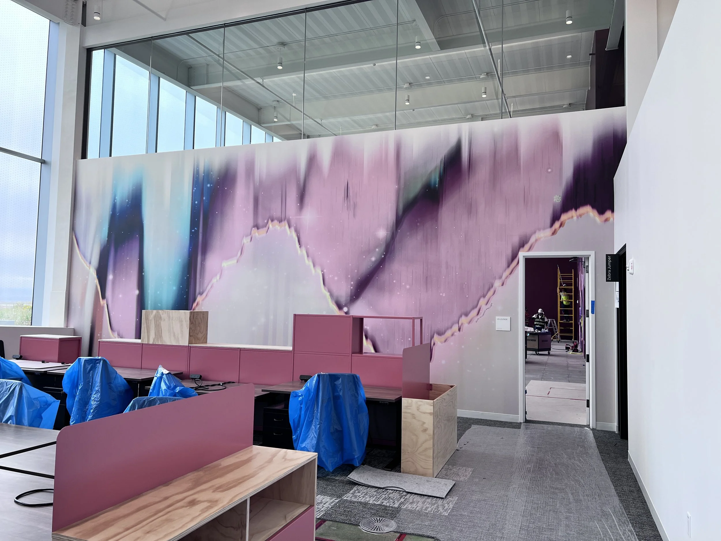 Abstract gradient wallcovering installed in an open office to create a modern commercial feature wall.
