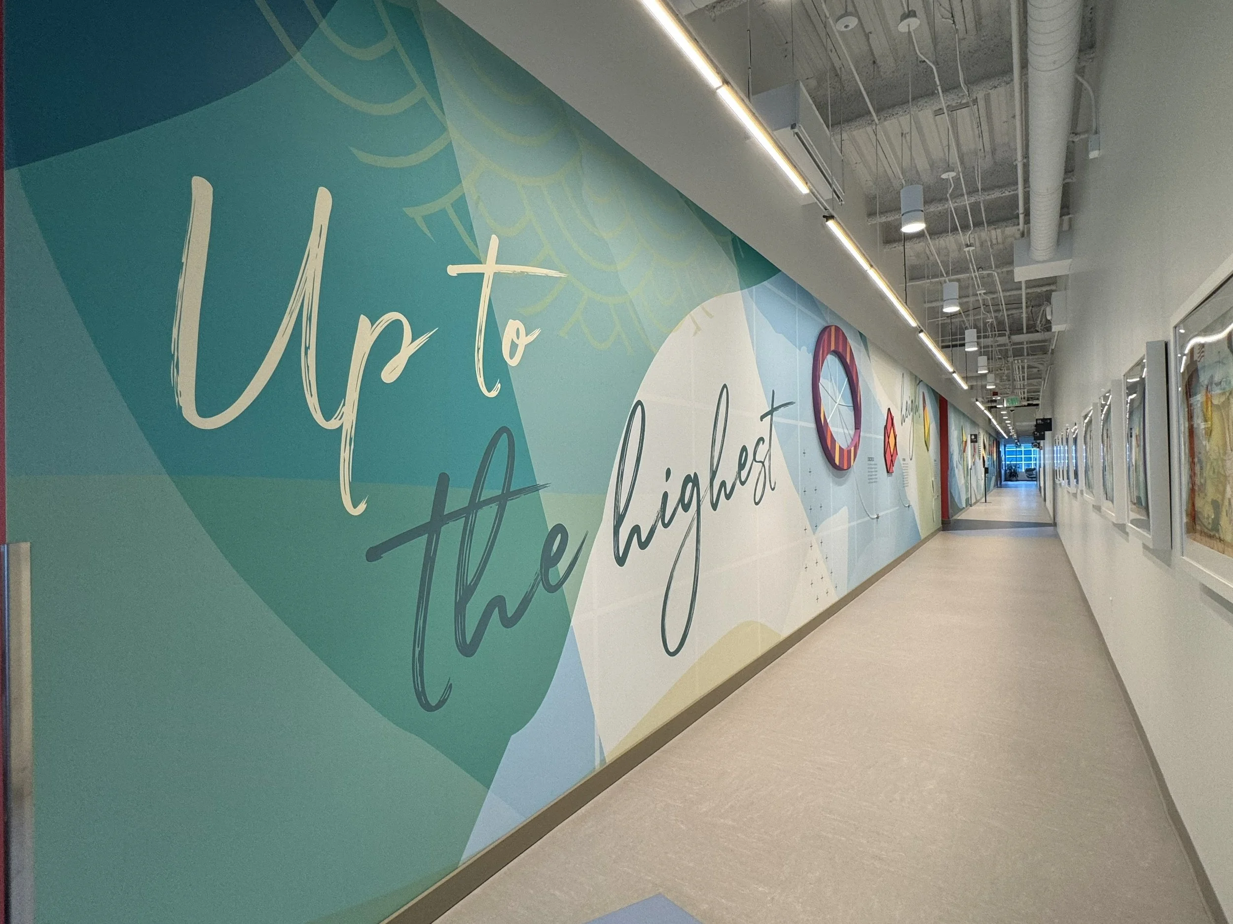 Large-scale motivational environmental graphics installed along corridor walls to enhance employee experience and brand culture.