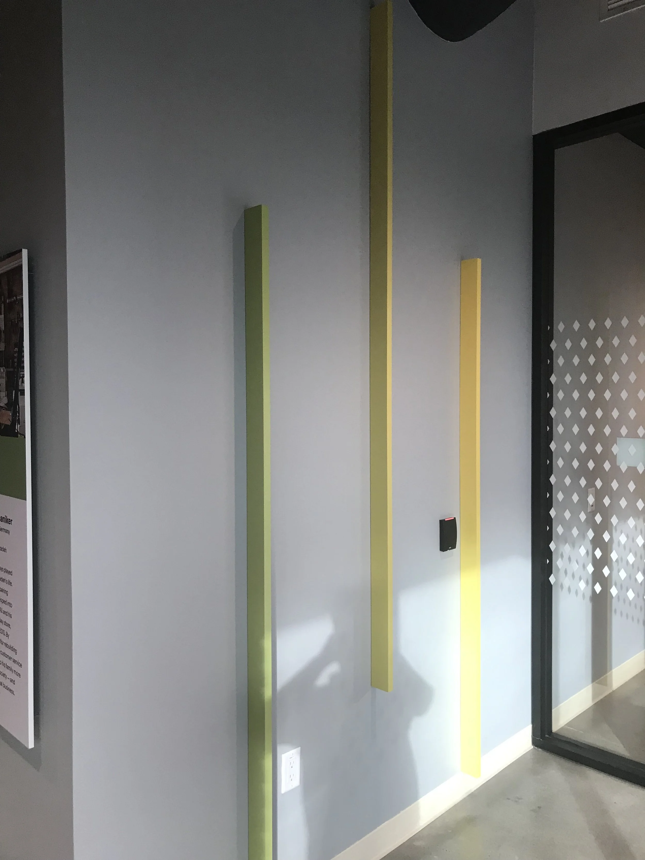 Minimal architectural feature wall incorporating dimensional accents and color to enhance interior branding.
