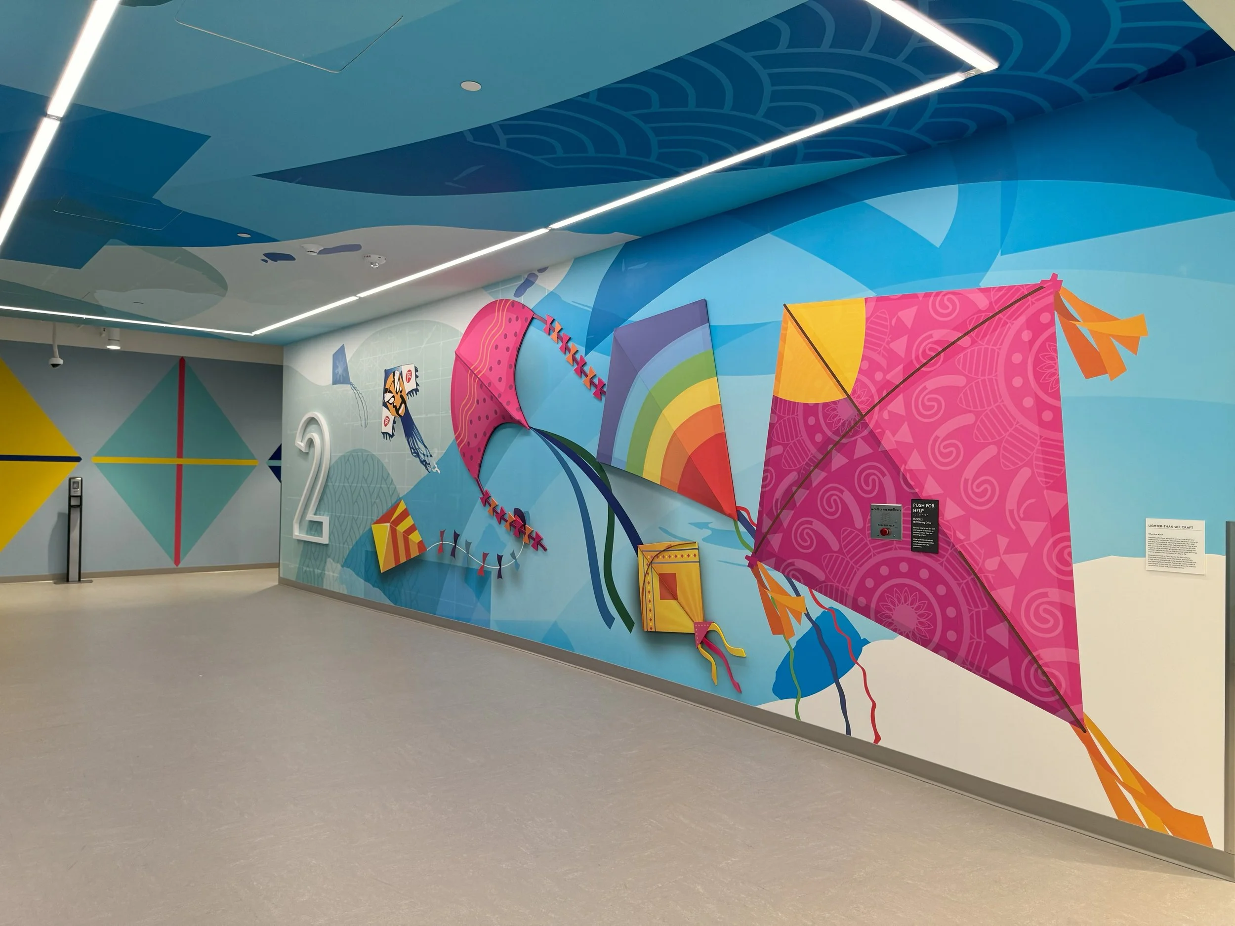 Large-format custom wall mural with vibrant graphics installed in modern office environment for branded interior design.
