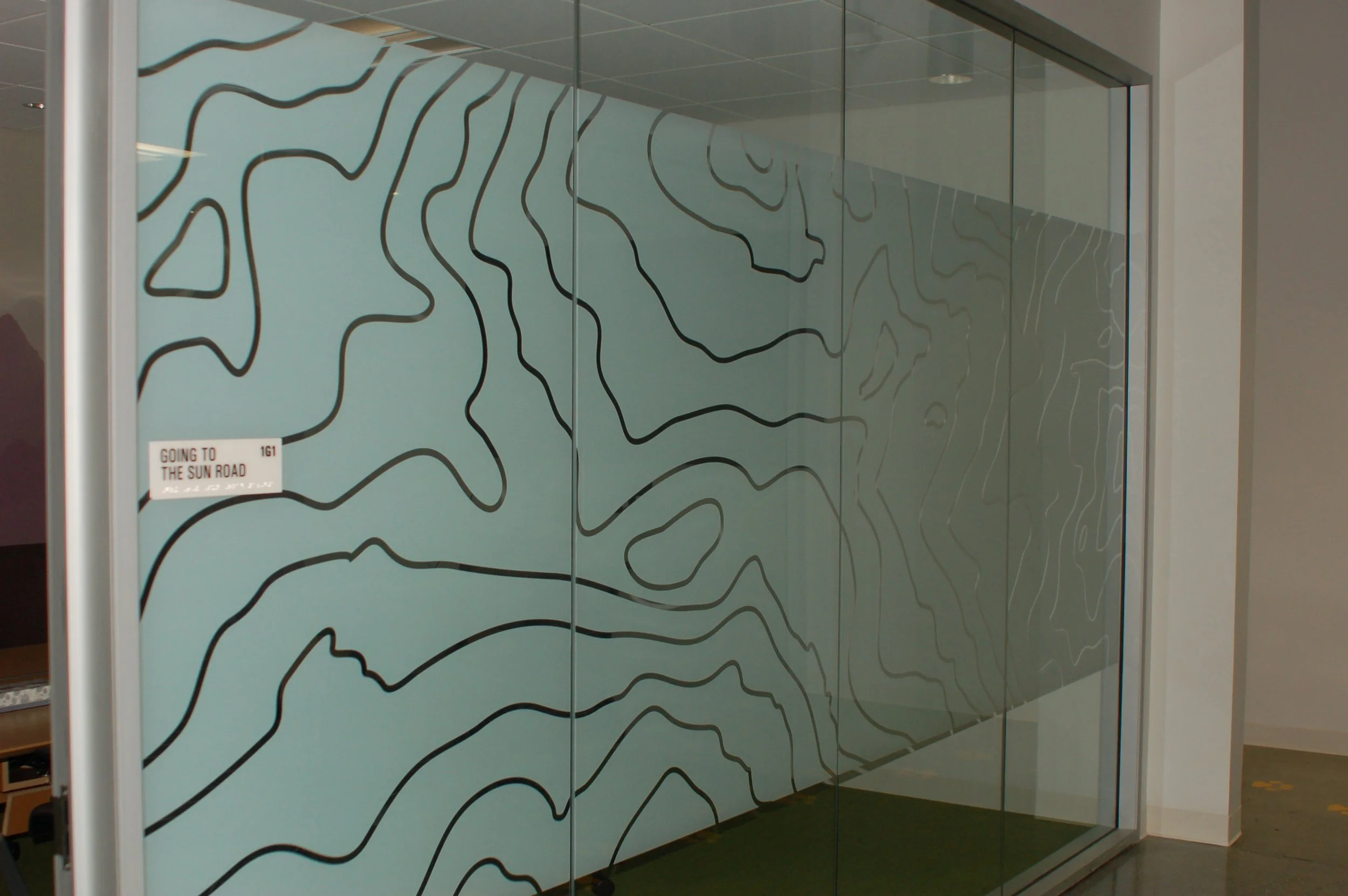 Commercial privacy window film installation on office glass featuring custom decorative pattern for modern workplace design