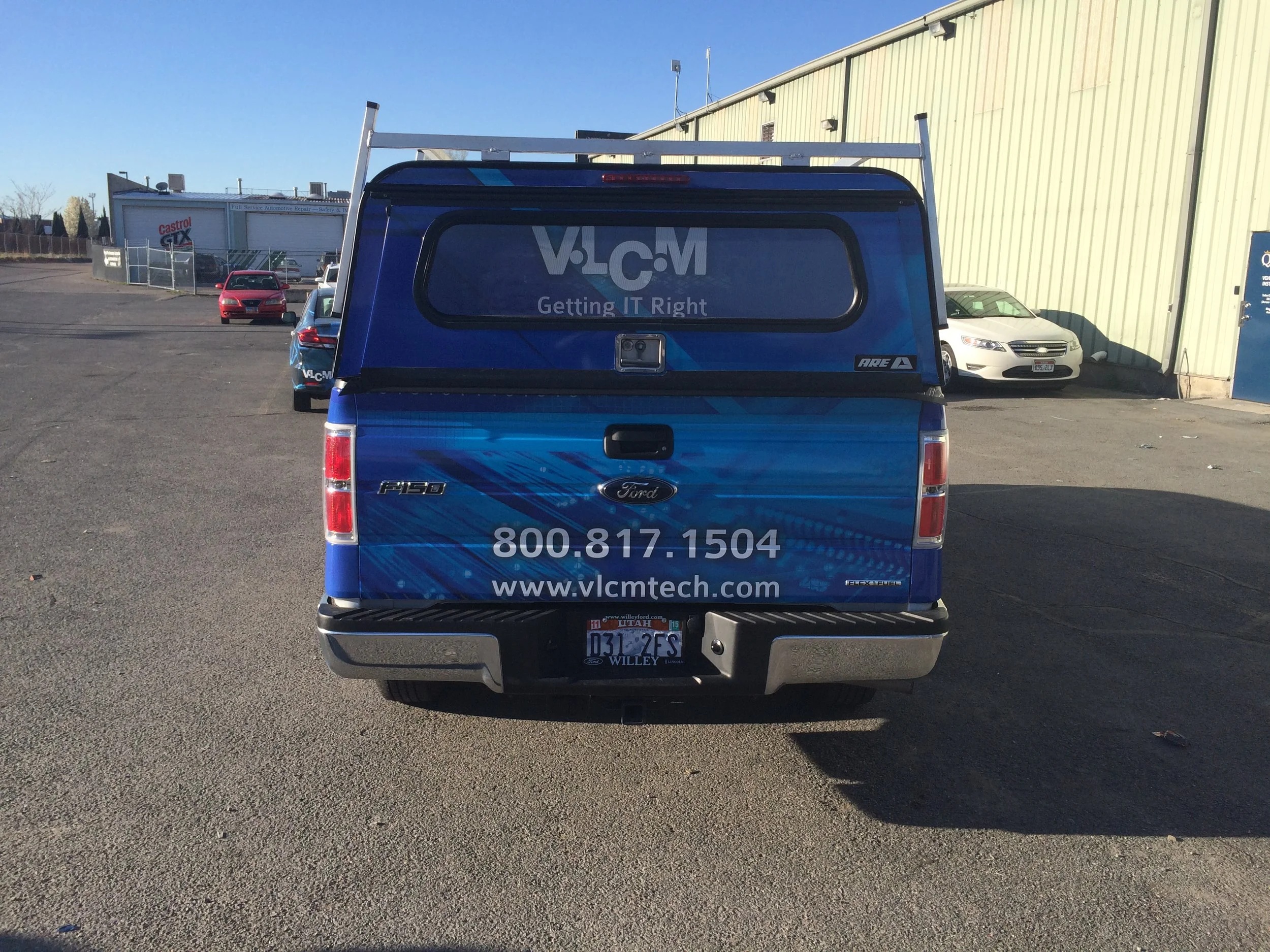 Rear view branded service pickup with vinyl vehicle graphics for fleet branding and business promotion.